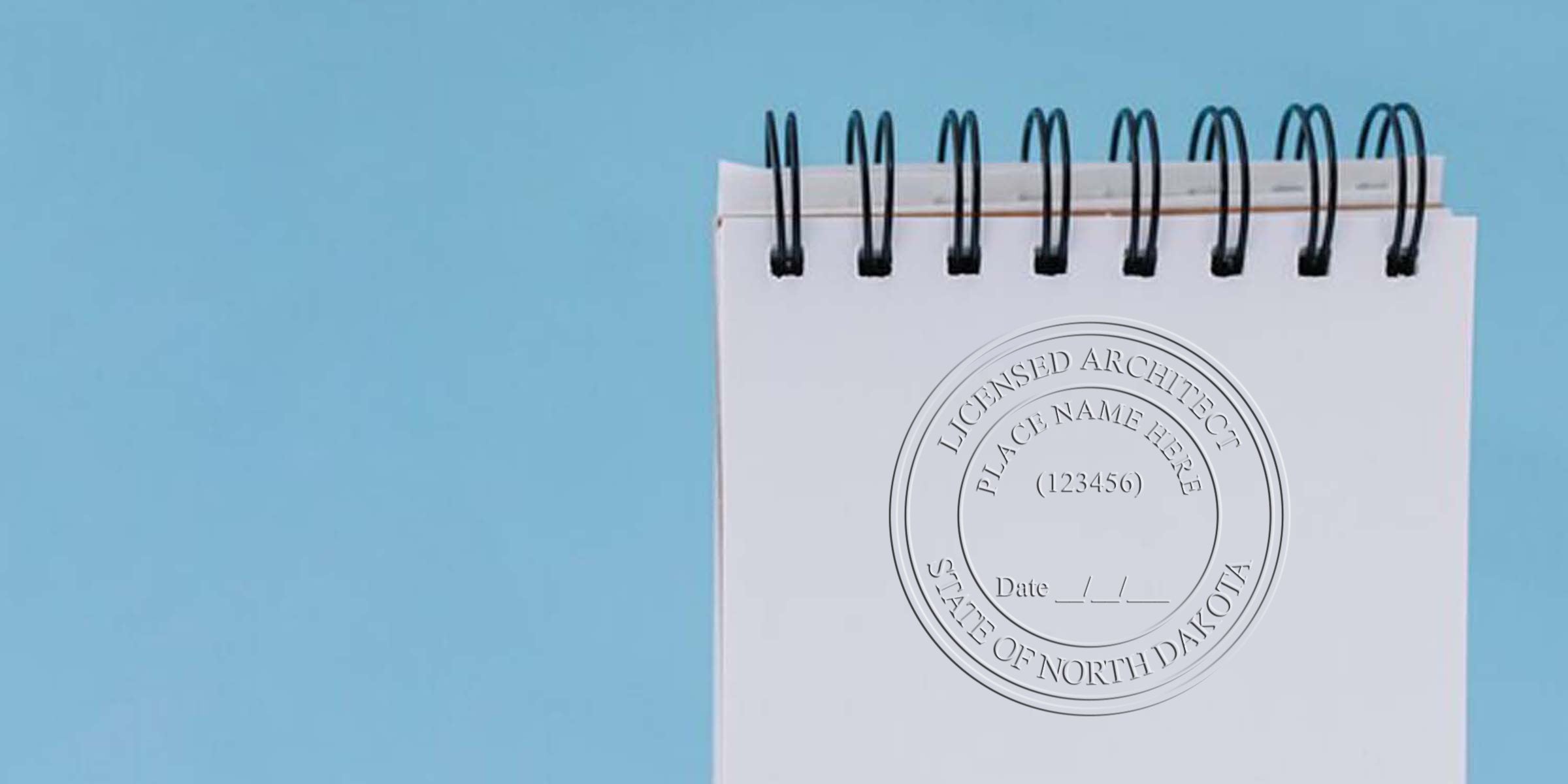 North Dakota architect seal with a unique design on a white spiral notebook set against a blue background.