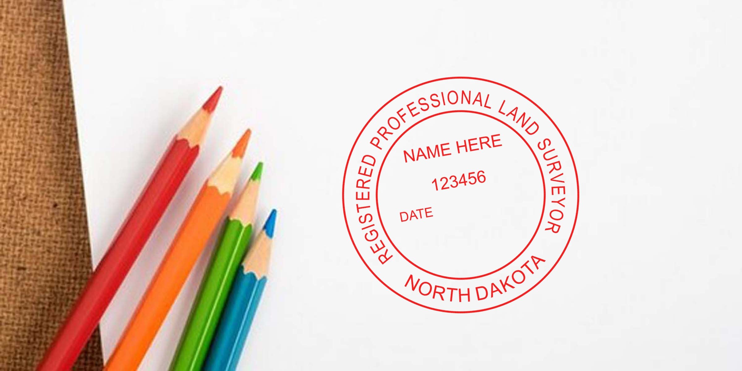 North Dakota surveyor stamp with registered land surveyor seal and colorful pencils on white paper, symbolizing affordable surveyor services.