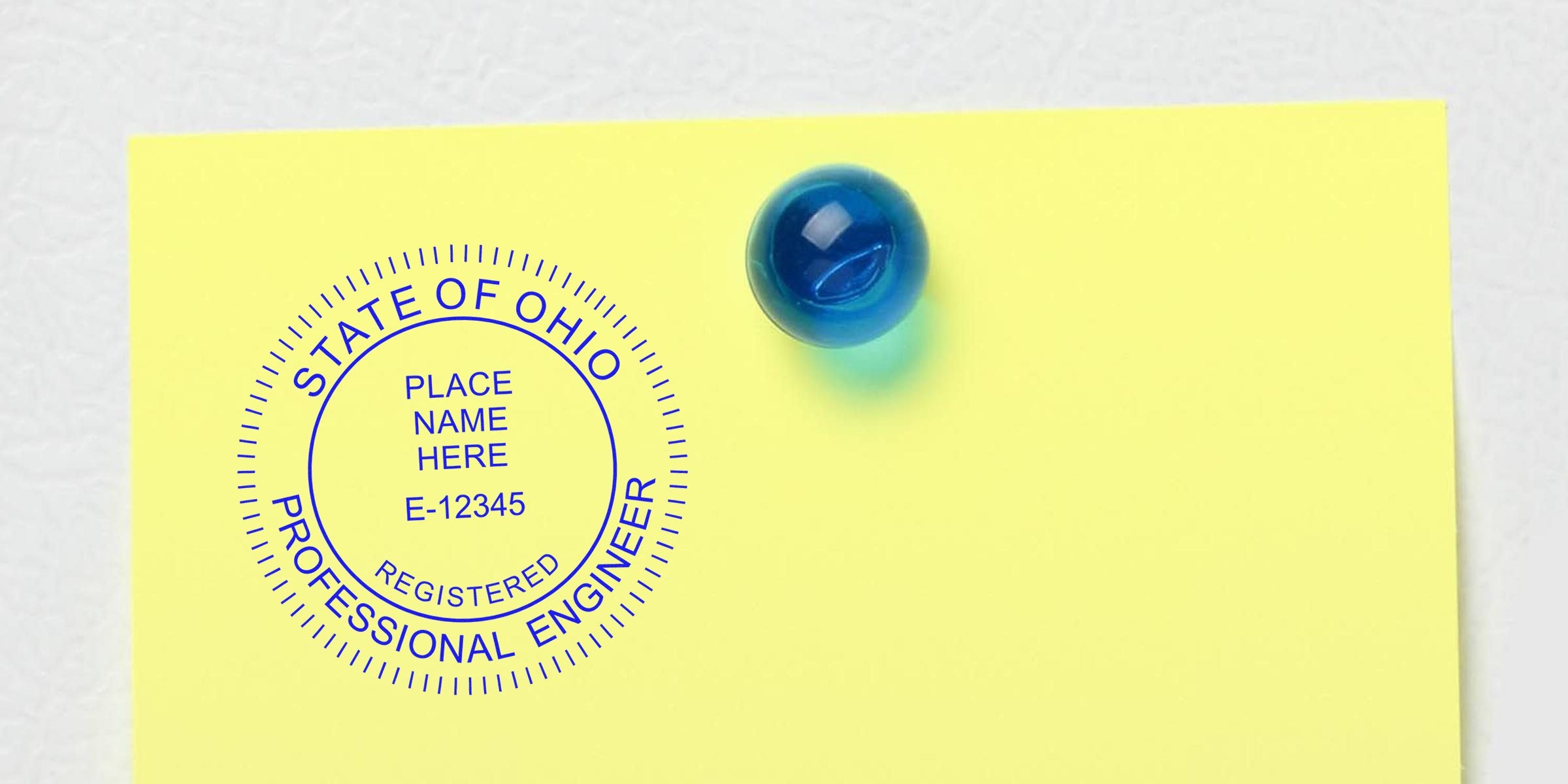 Ohio professional engineer stamp on yellow paper with blue pushpin, symbolizing Ohio PE stamp replacement.