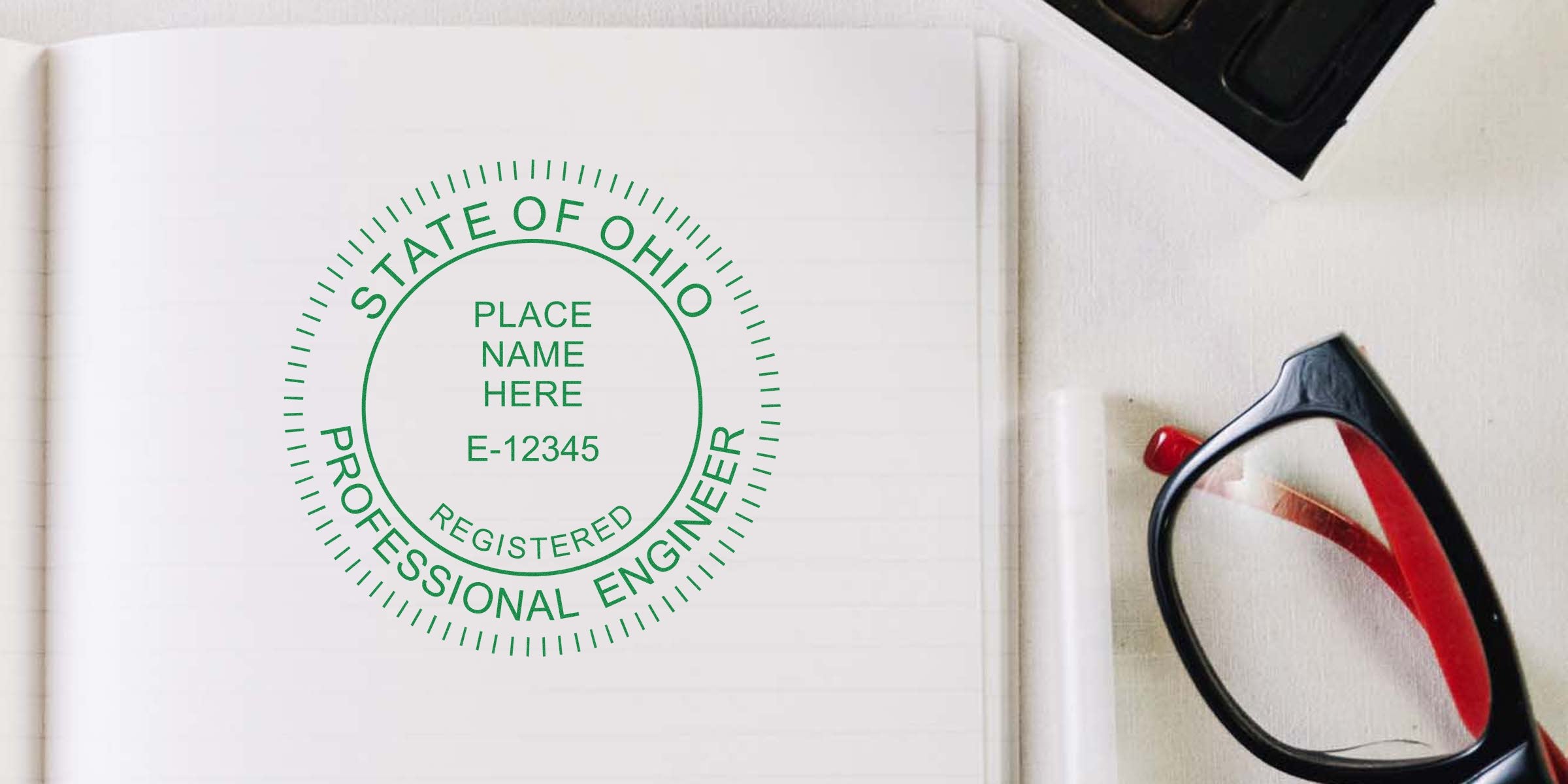Custom Ohio engineer seal stamp on white paper with black and red eyeglasses nearby, highlighting personalized engineer stamps.
