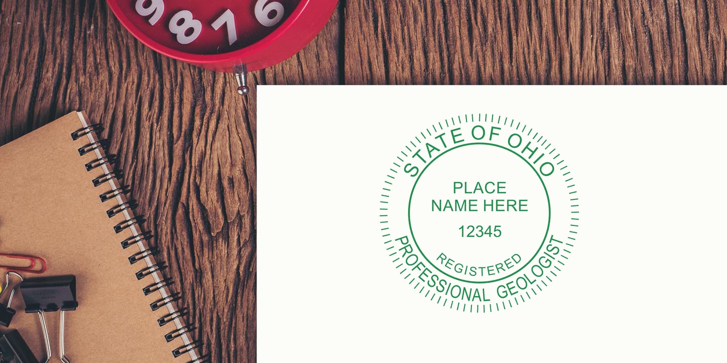 Geologist Seal Ohio stamped on white paper next to a notebook and red clock on a wooden desk, symbolizing Ohio Geological Certification.