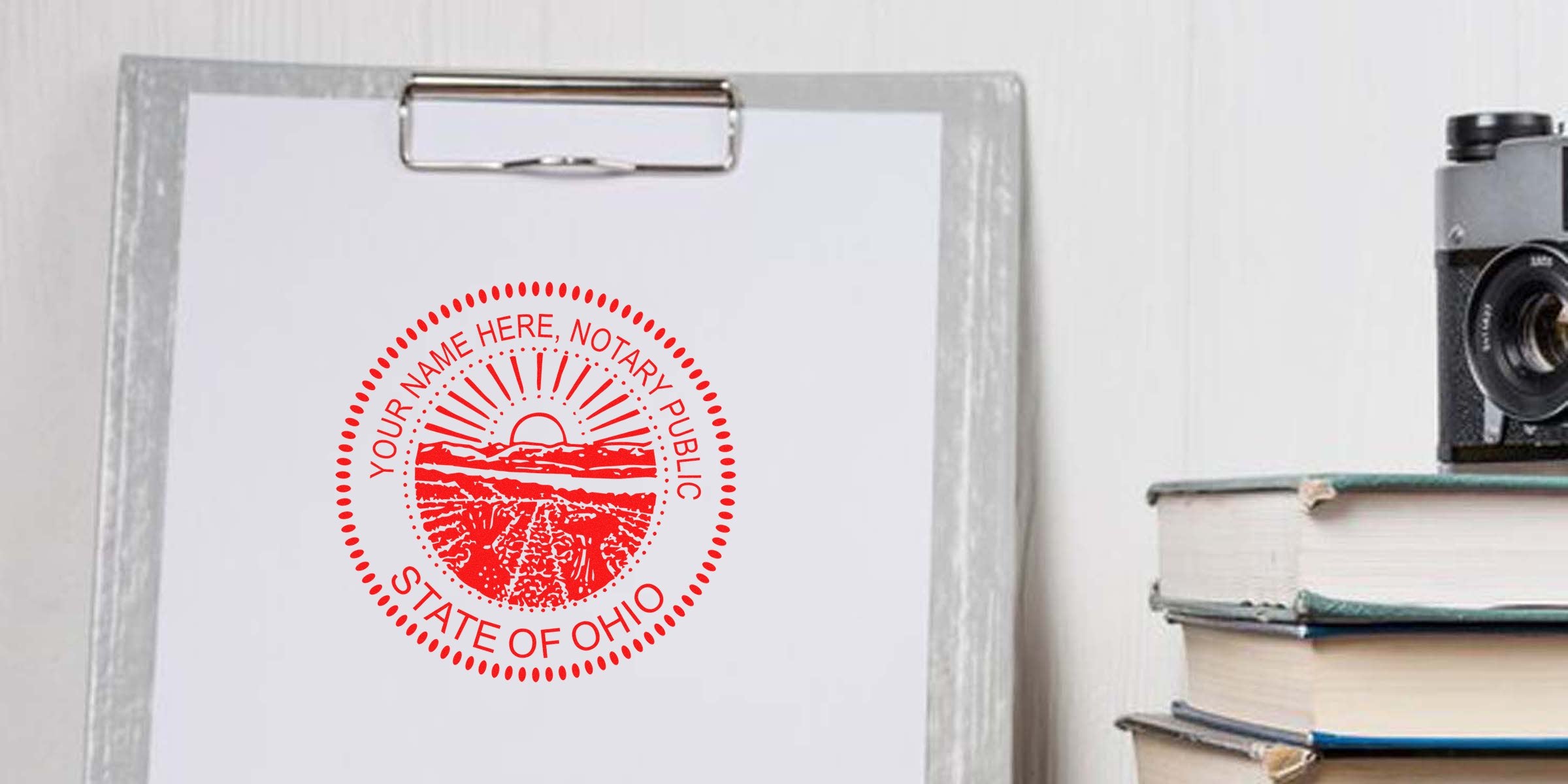 Ohio notary stamp format shown on a clipboard with a vintage camera and books, featuring a sample Ohio notary stamp.