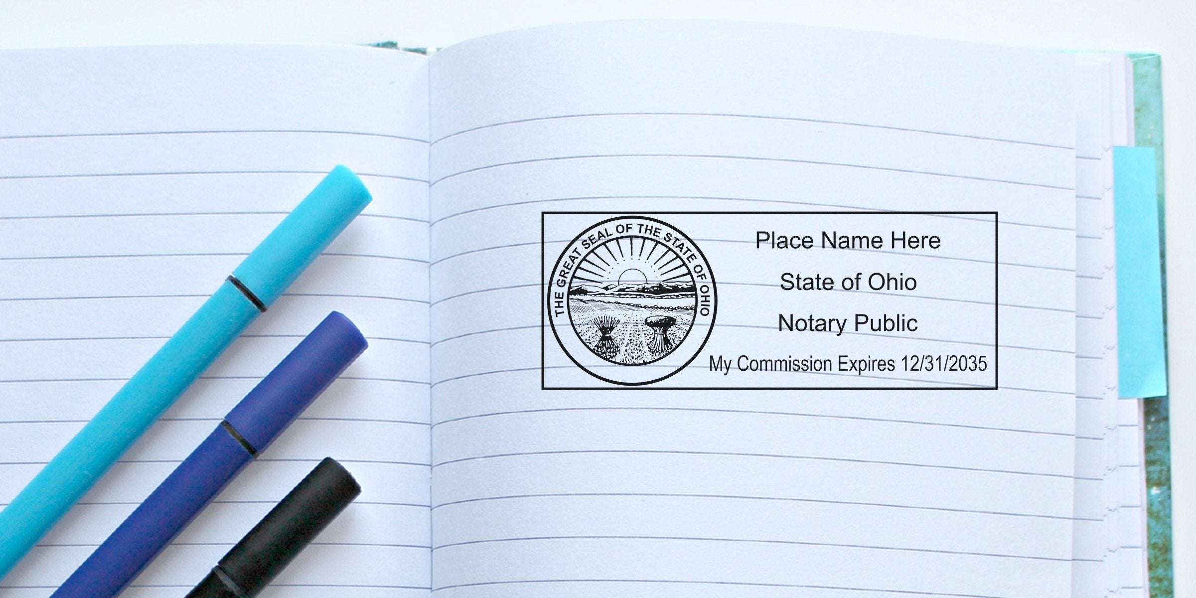 Ohio notary stamp on an open notebook with blue and black pens, showing a self-inking notary stamp.