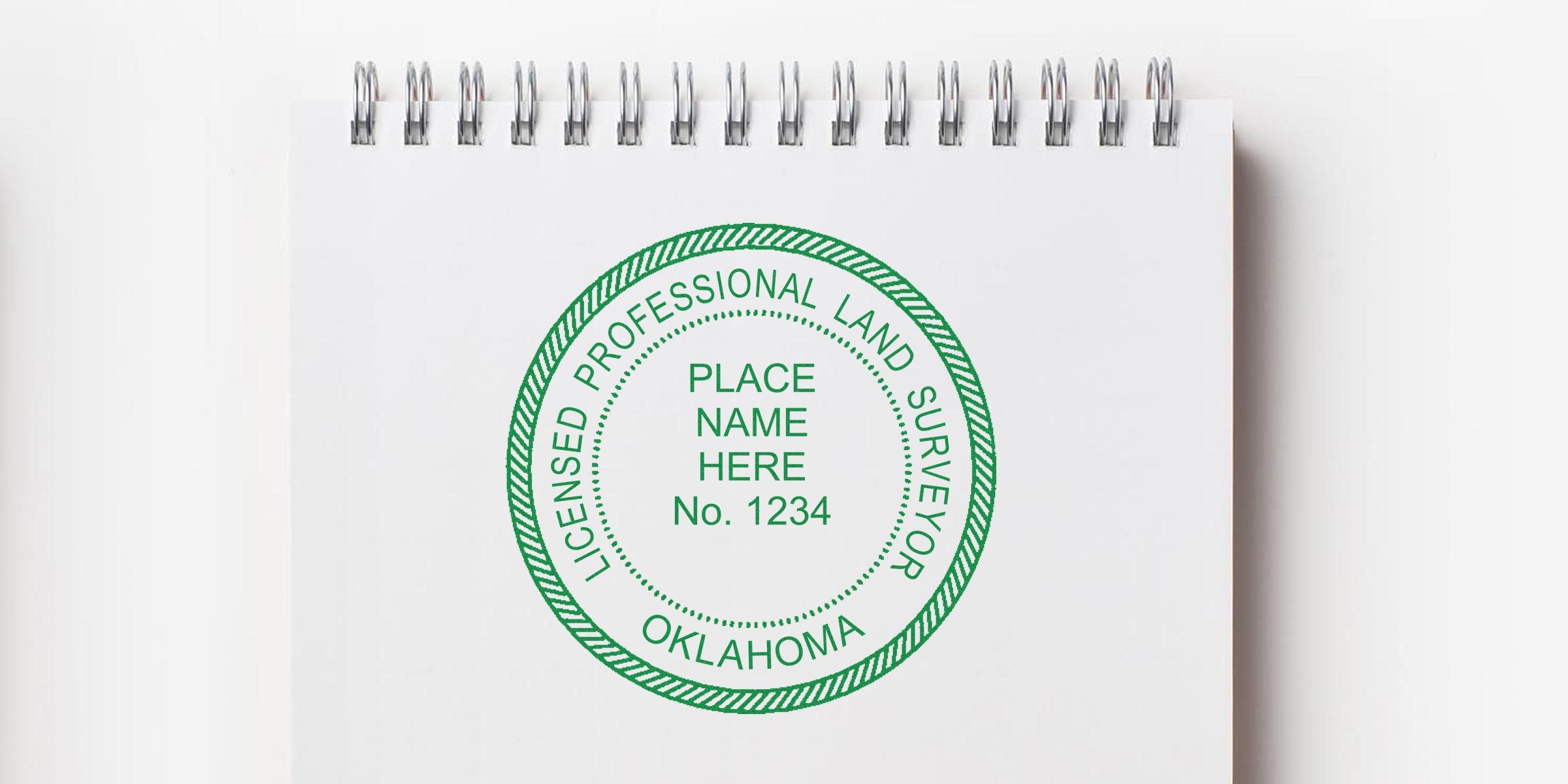 Licensed Oklahoma land surveyor stamp on white spiral notebook, adhering to land surveyor stamp guidelines.