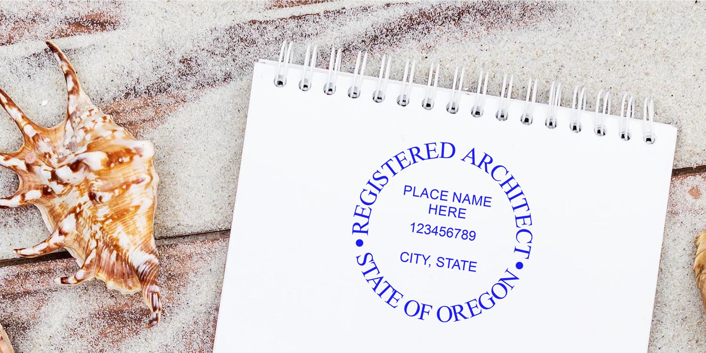 Oregon architect seal stamped on white notepad with seashell on sandy beach, capturing the seal stamping process.