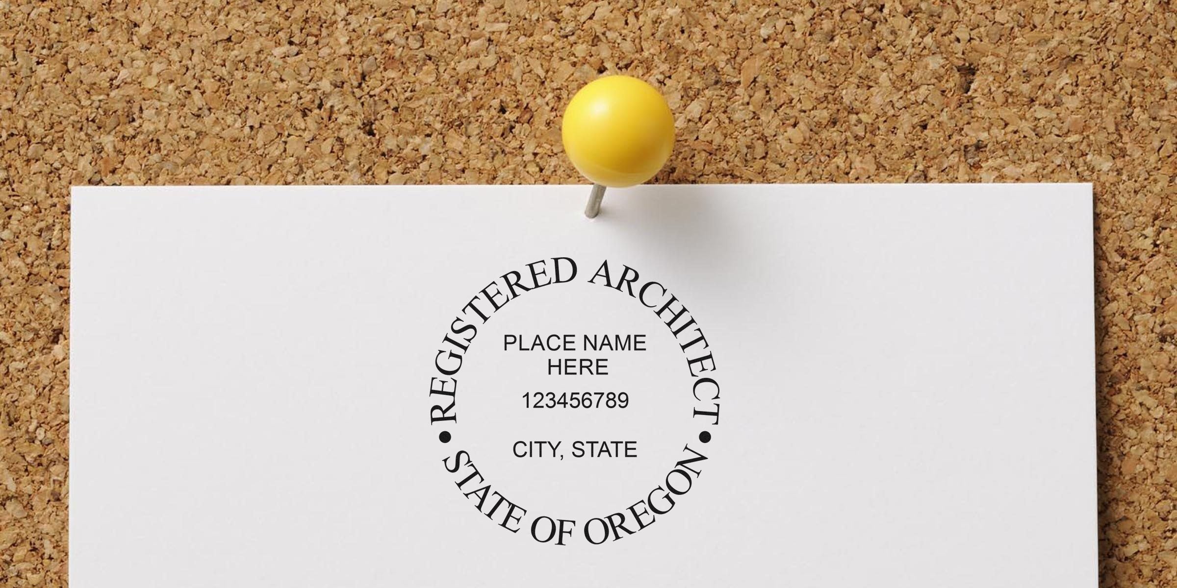 Registered architect seal pinned on corkboard with yellow push pin, showing Oregon architect stamp size and specifications for official certification.