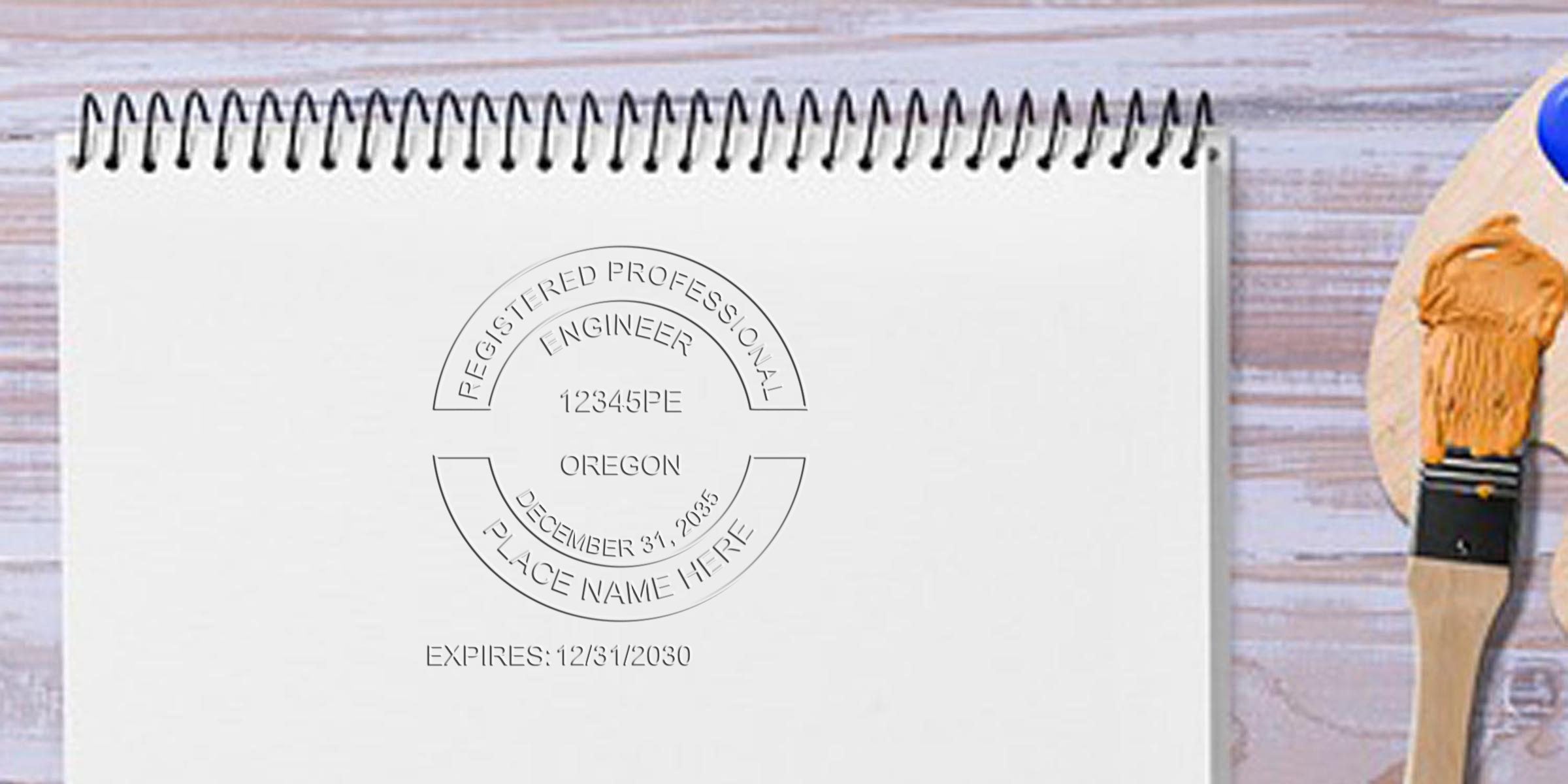 Registered Professional Engineer seal on white notebook with paintbrush and palette on wooden table, showcasing Professional Engineer and Oregon Engineer stamps for certification and license verification.