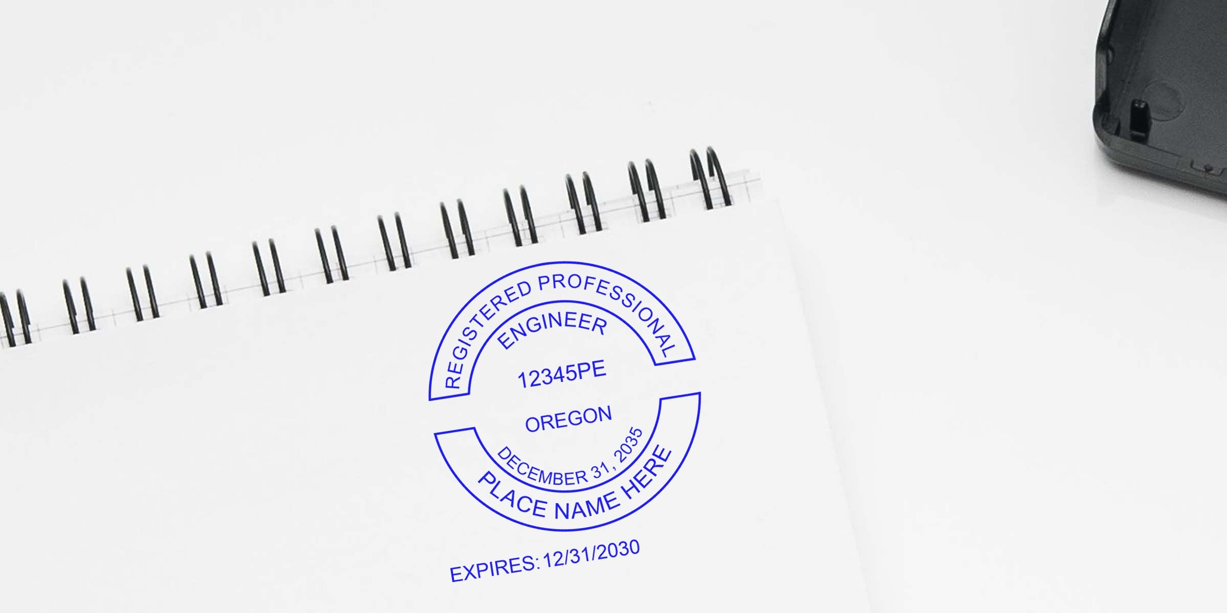 Oregon professional engineer stamp with expiration date on white spiral notebook, highlighting certification verification, stamp cost, and tips to save on engineer stamp fees.