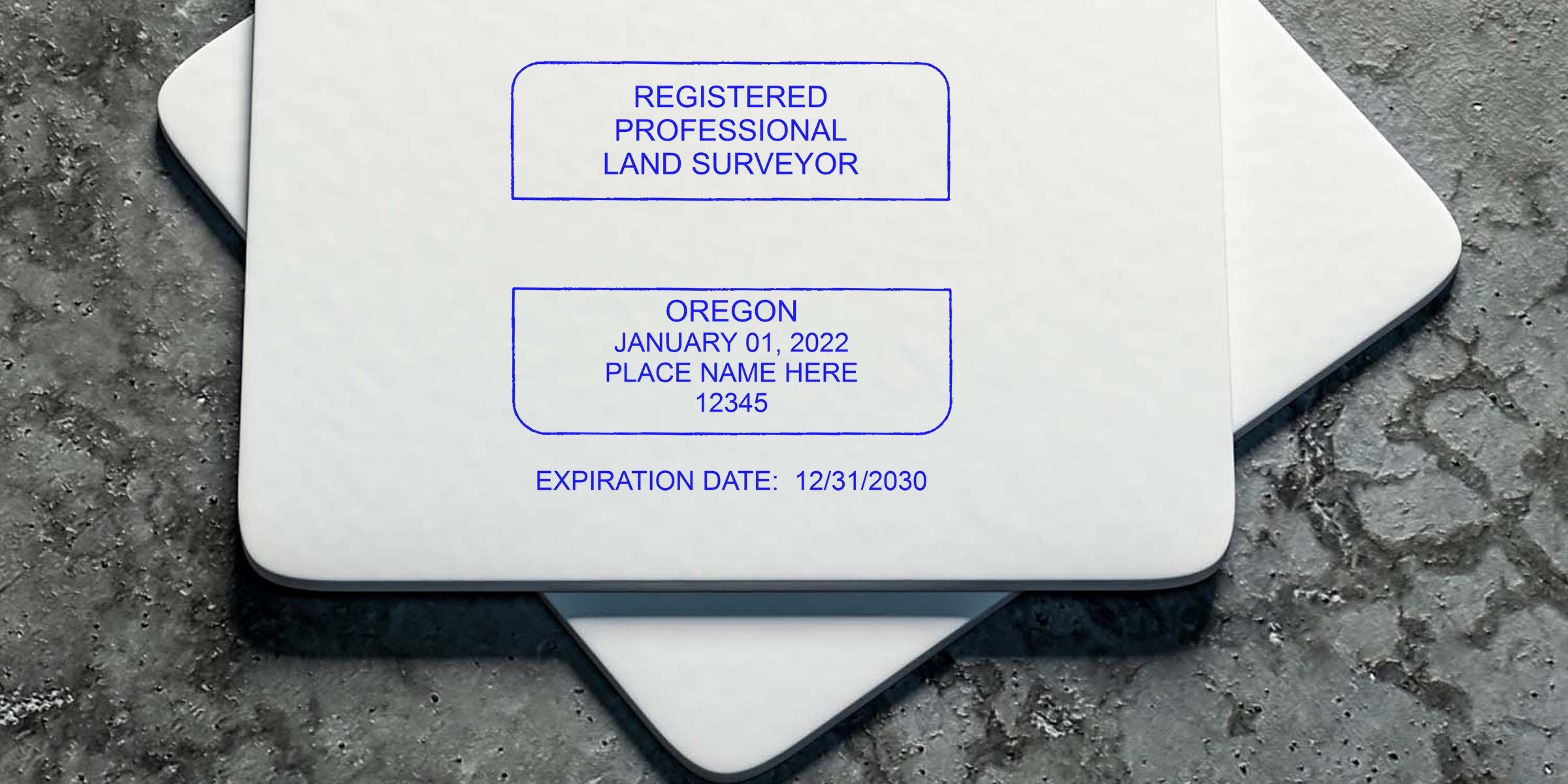 Oregon land surveyor stamp engraved on textured concrete, showing registered professional land surveyor seal with expiration date.