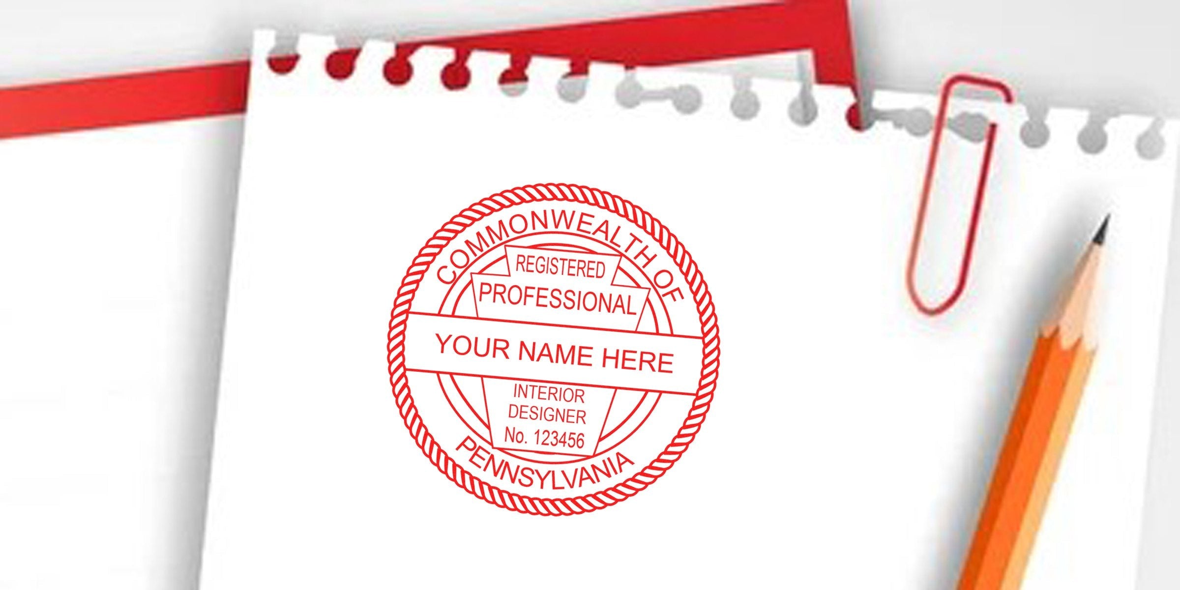 Custom Pennsylvania interior designer stamp on white paper with pencil and red paperclip, showing registered design certification seal, highlighting stamp cost and interior design fee budgeting.