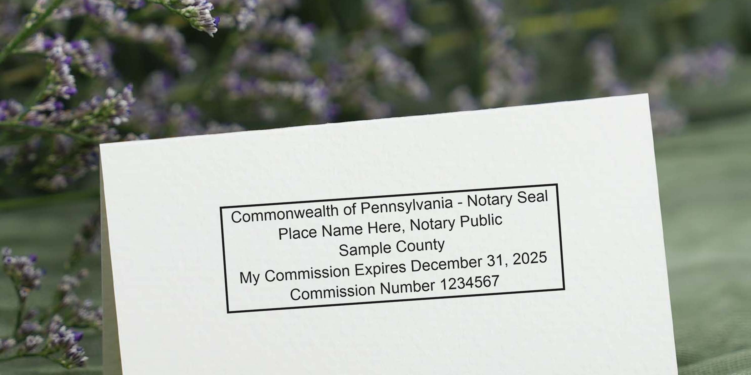 Sample of Pennsylvania notary stamp with commission expiration date on white card, displaying notary stamp and format examples.