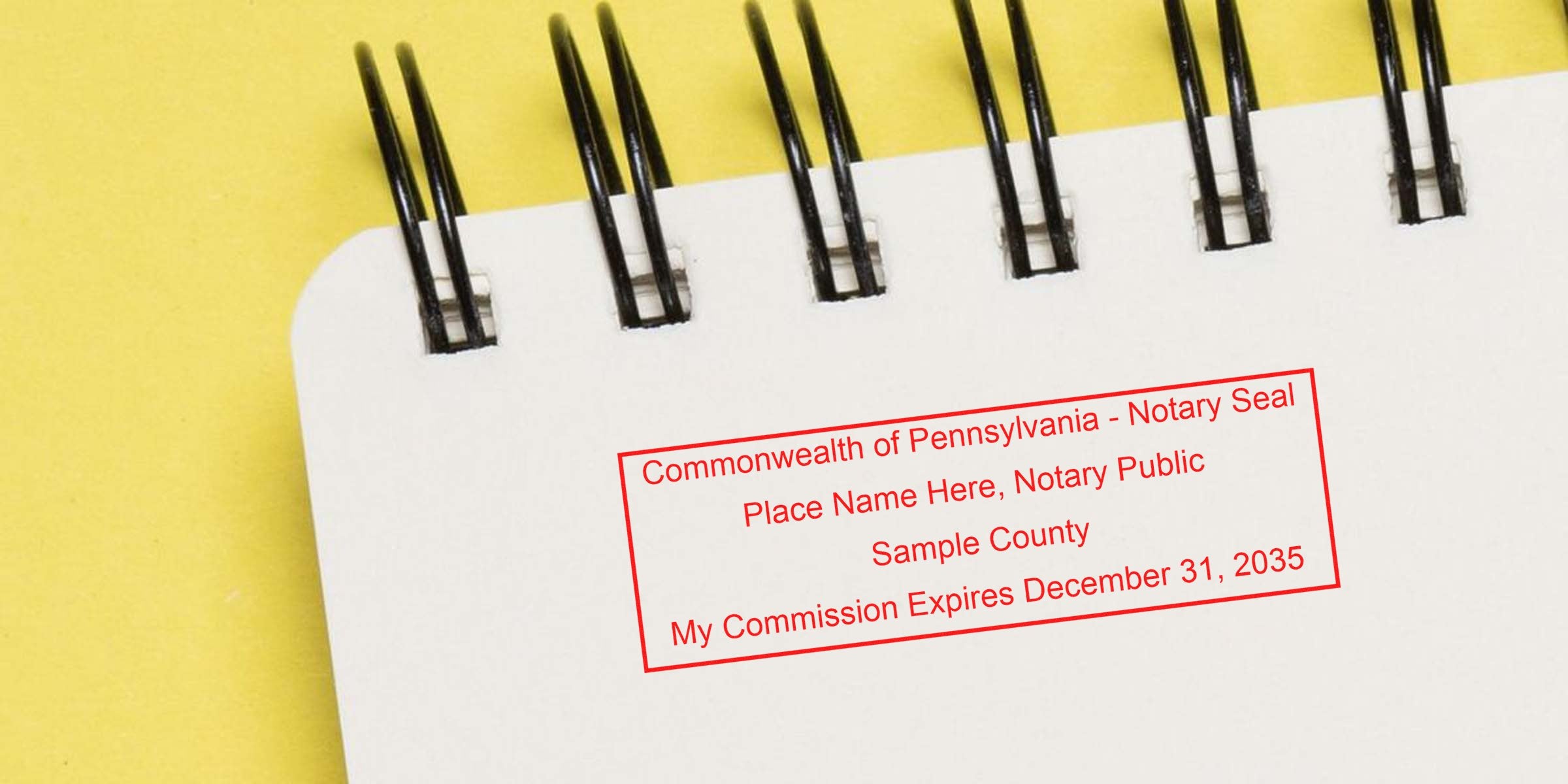 Self-inking Pennsylvania notary stamp on notebook page showing official seal and commission expiration date.