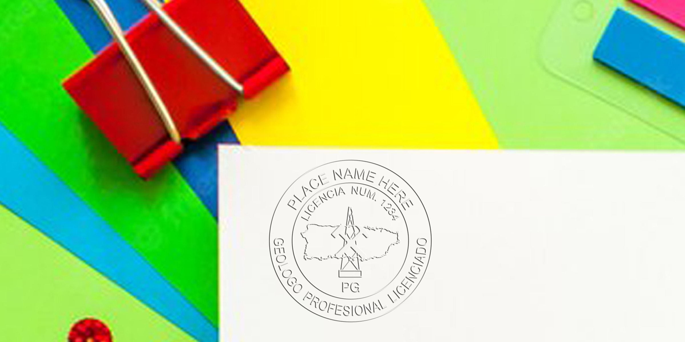 Red binder clip holds colorful paper and a white card with a licensed geologist stamp, showcasing geologist stamp prices and Puerto Rico geology stamps.