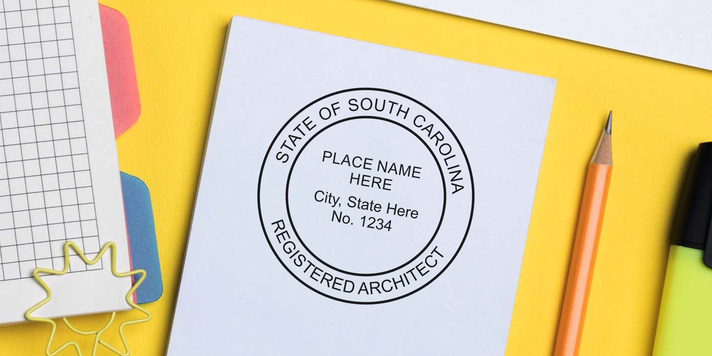 South Carolina architect seal stamp on white paper with office supplies on yellow background, showing South Carolina architect seal and license.