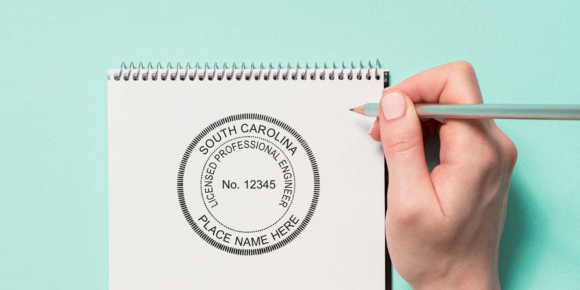 Hand holding pencil sketching SC engineer stamp on notebook, symbolizing engineering license renewal and simplifying the purchase process.