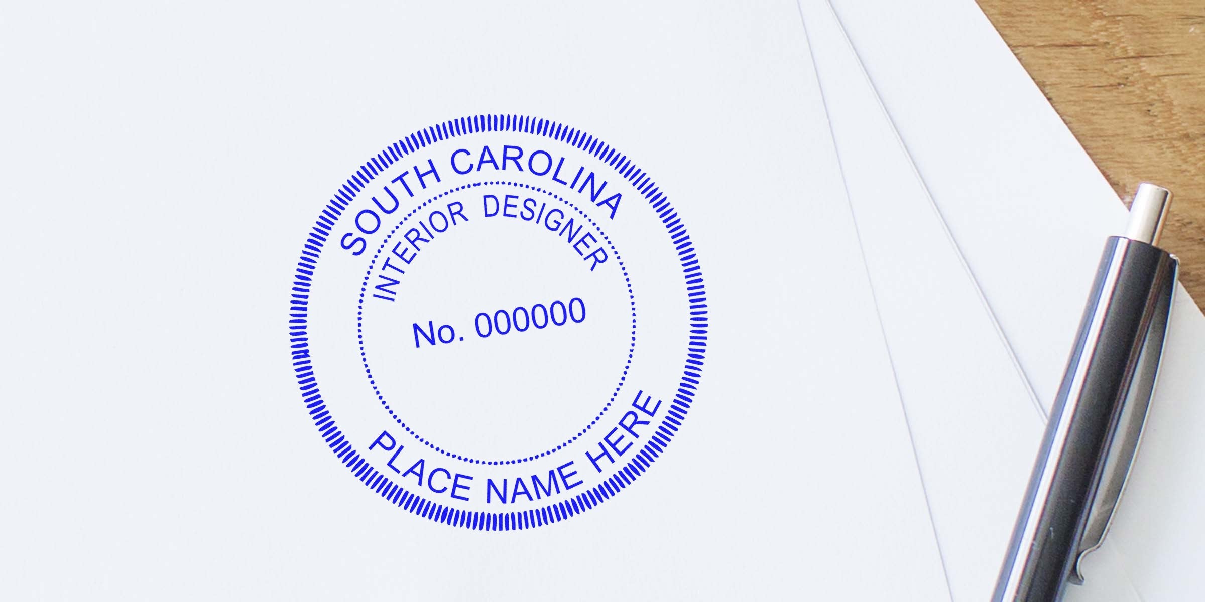 South Carolina interior designer stamp on white paper with pen on wooden desk, showing SC interior design regulations and seal requirements.