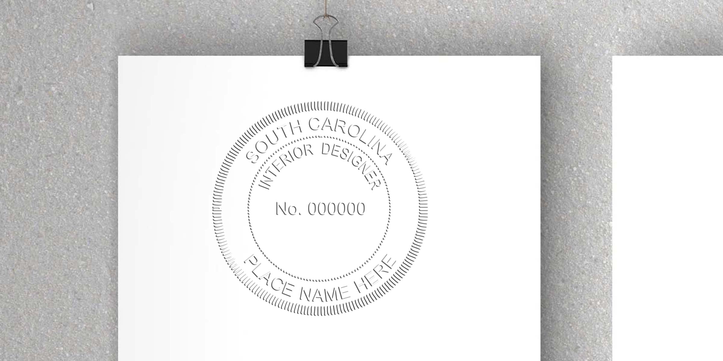 Official South Carolina interior designer license stamp on white paper, held by a black binder clip, symbolizing the interior designer licensing process.
