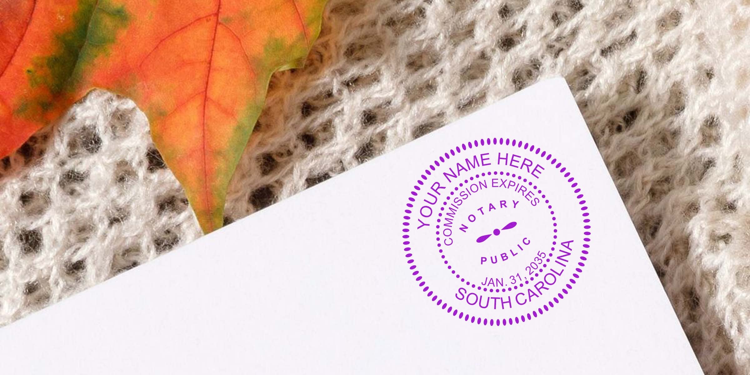 Quality Notary Stamp SC on white paper with autumn leaf and knitted fabric background, emphasizing the significance of a notary stamp.