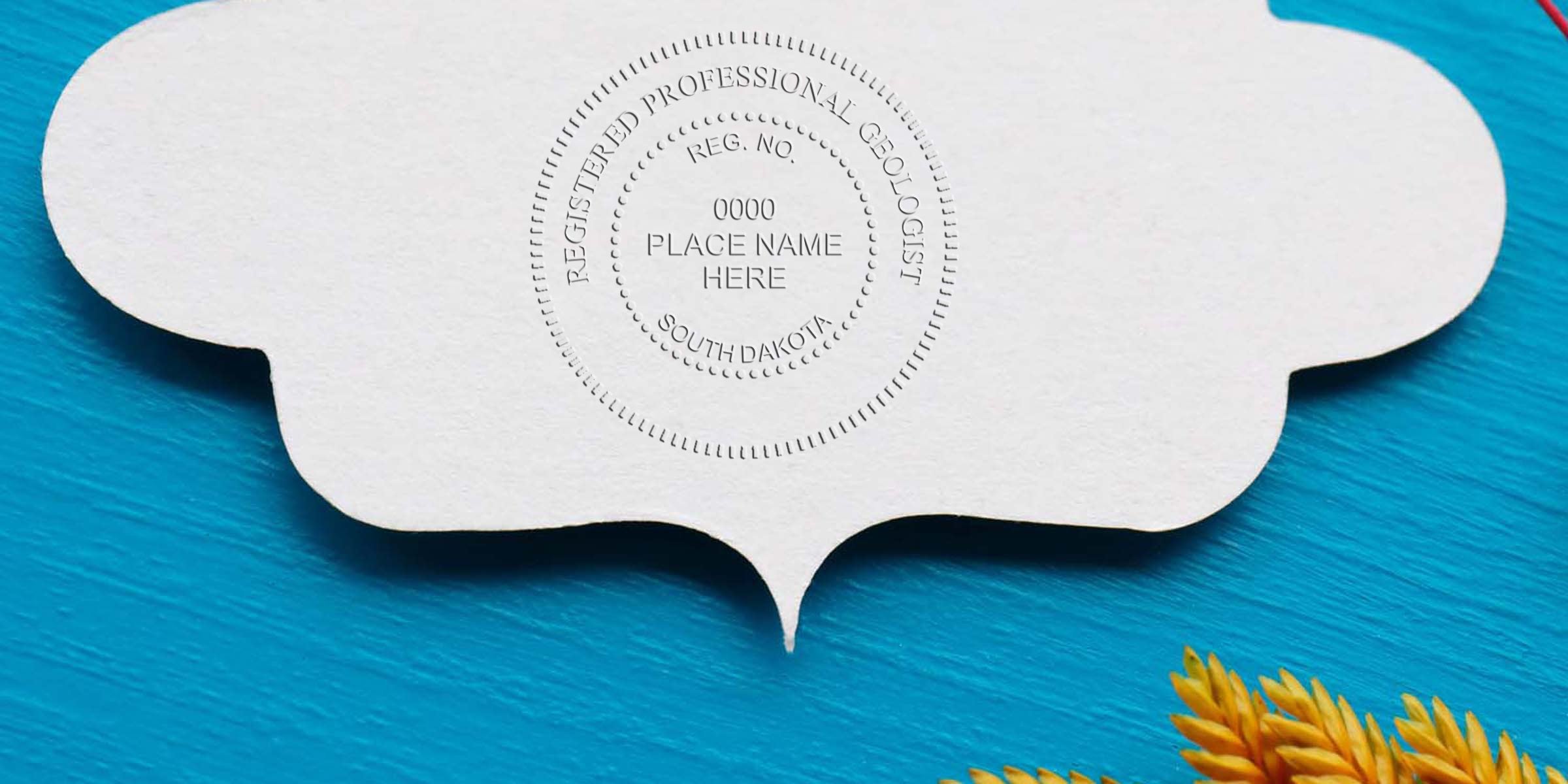 Registered South Dakota geologist seal embossed on white paper with blue background and yellow plant detail, meeting all geologist seal design requirements.