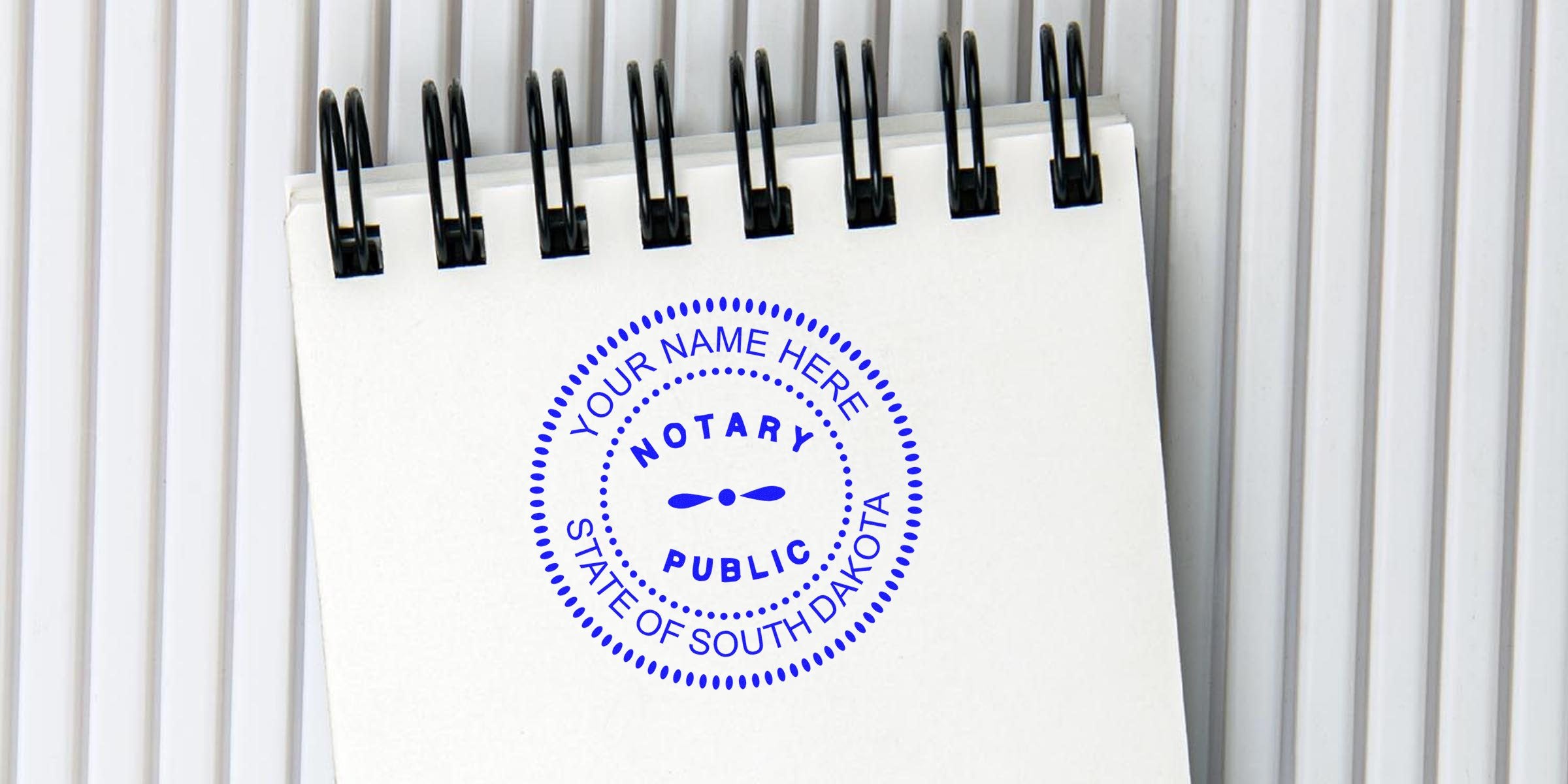 Notary public stamp on spiral notebook with South Dakota seal and customizable name area, meeting notary seal guidelines.