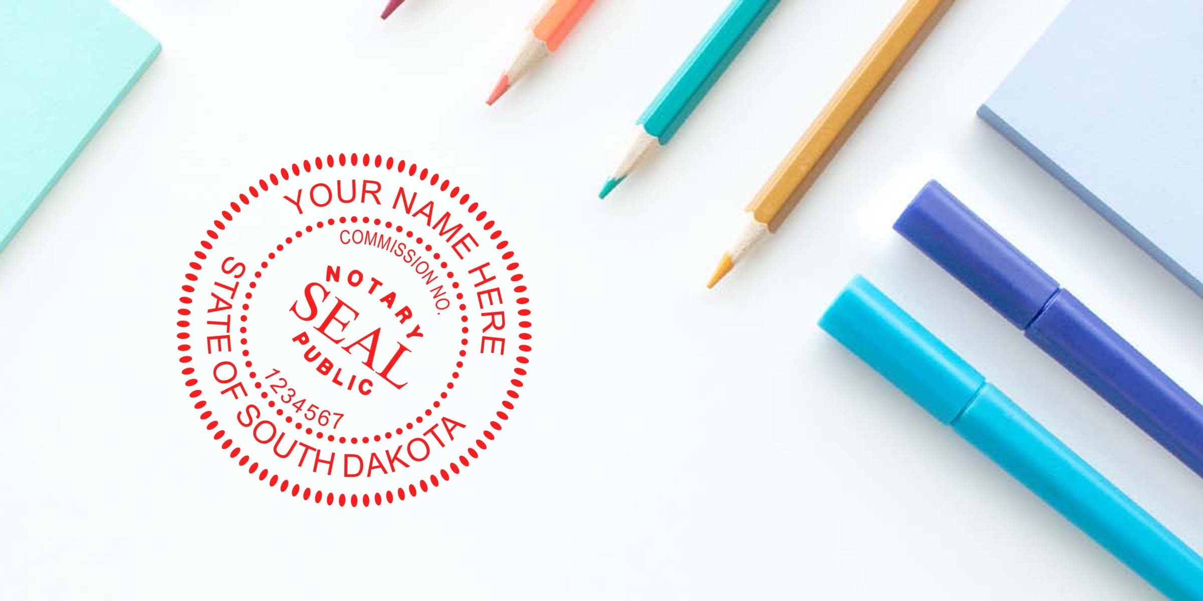 South Dakota notary stamp on white desk with colored pencils and markers, displaying a sample notary stamp format.