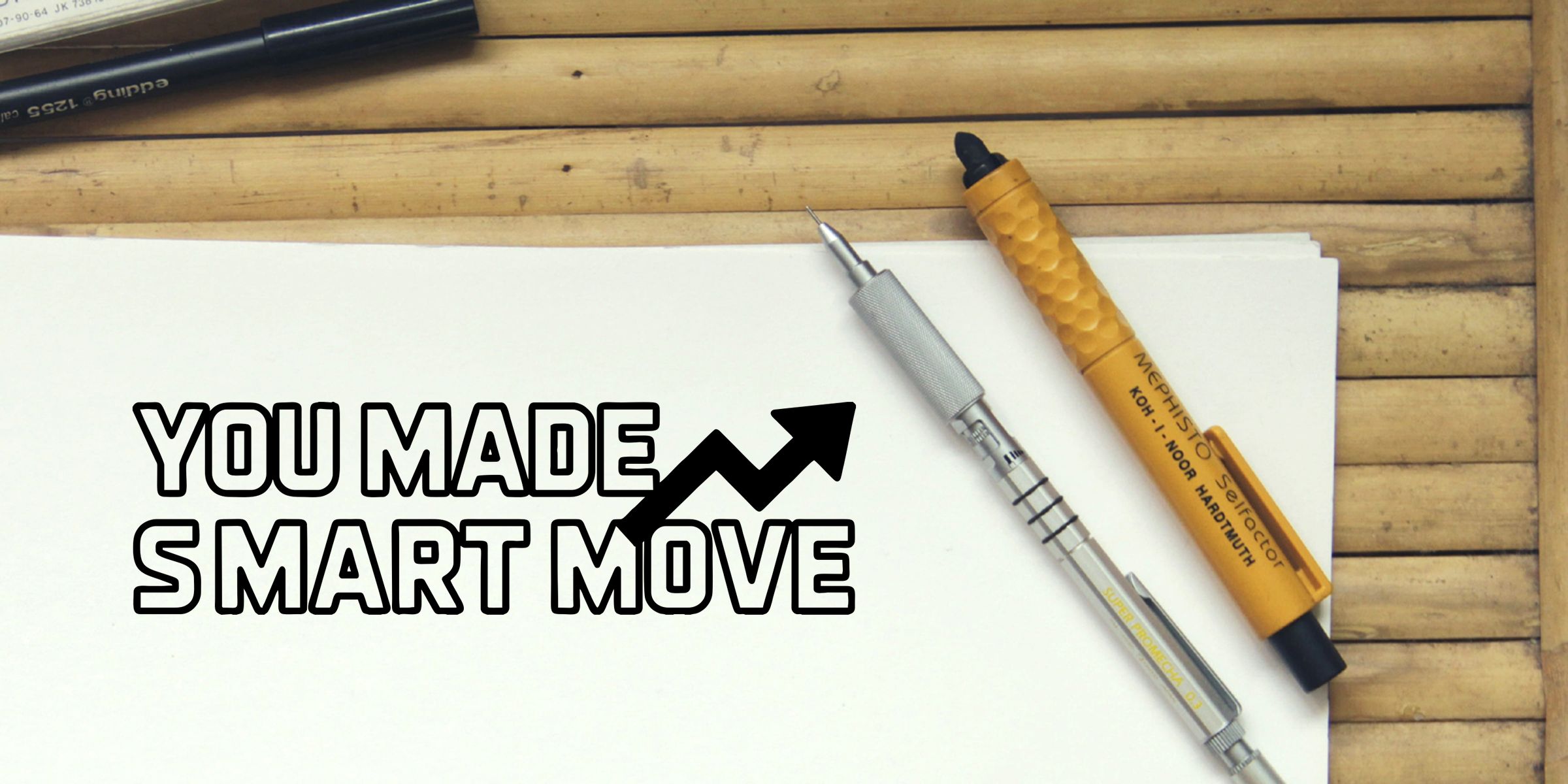 Motivational business design on white paper with bold “You Made Smart Move” text, upward arrow graphic, and pens on a bamboo desk background