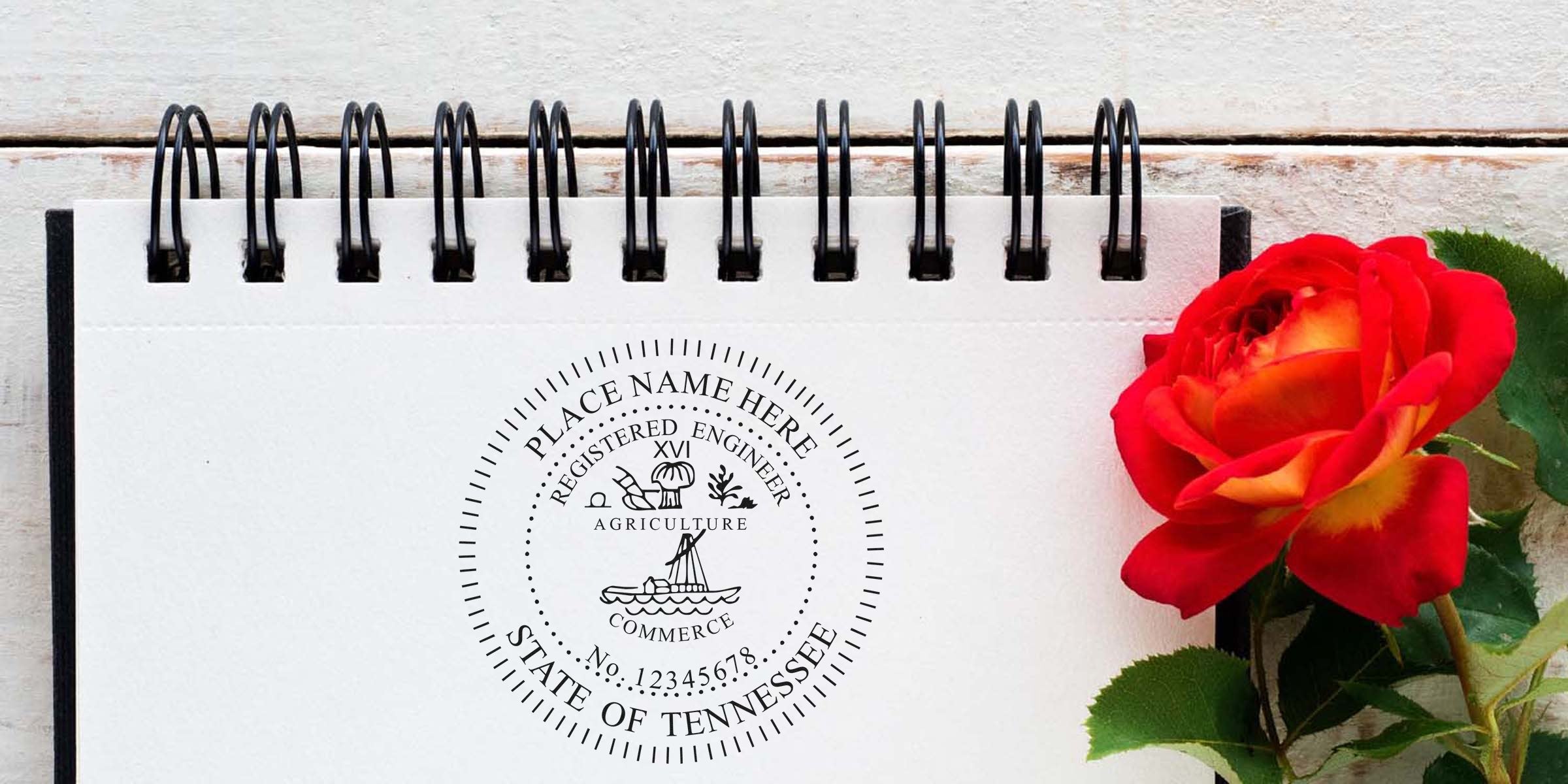 Professional Engineer Seal Tennessee stamped on notebook with red rose and green leaves on wooden table, symbolizing Engineering Project Approval in Tennessee.