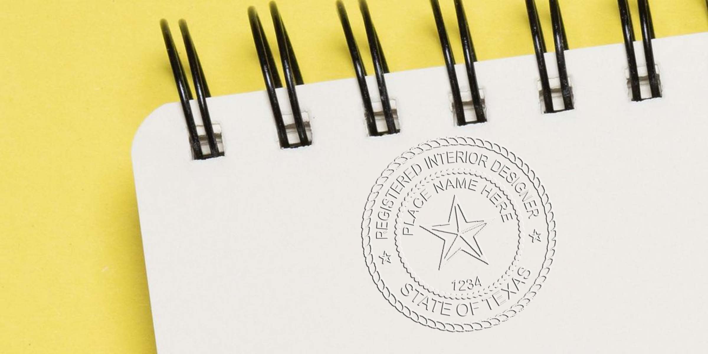 Texas interior designer seal embossed on white spiral notebook against a yellow background.