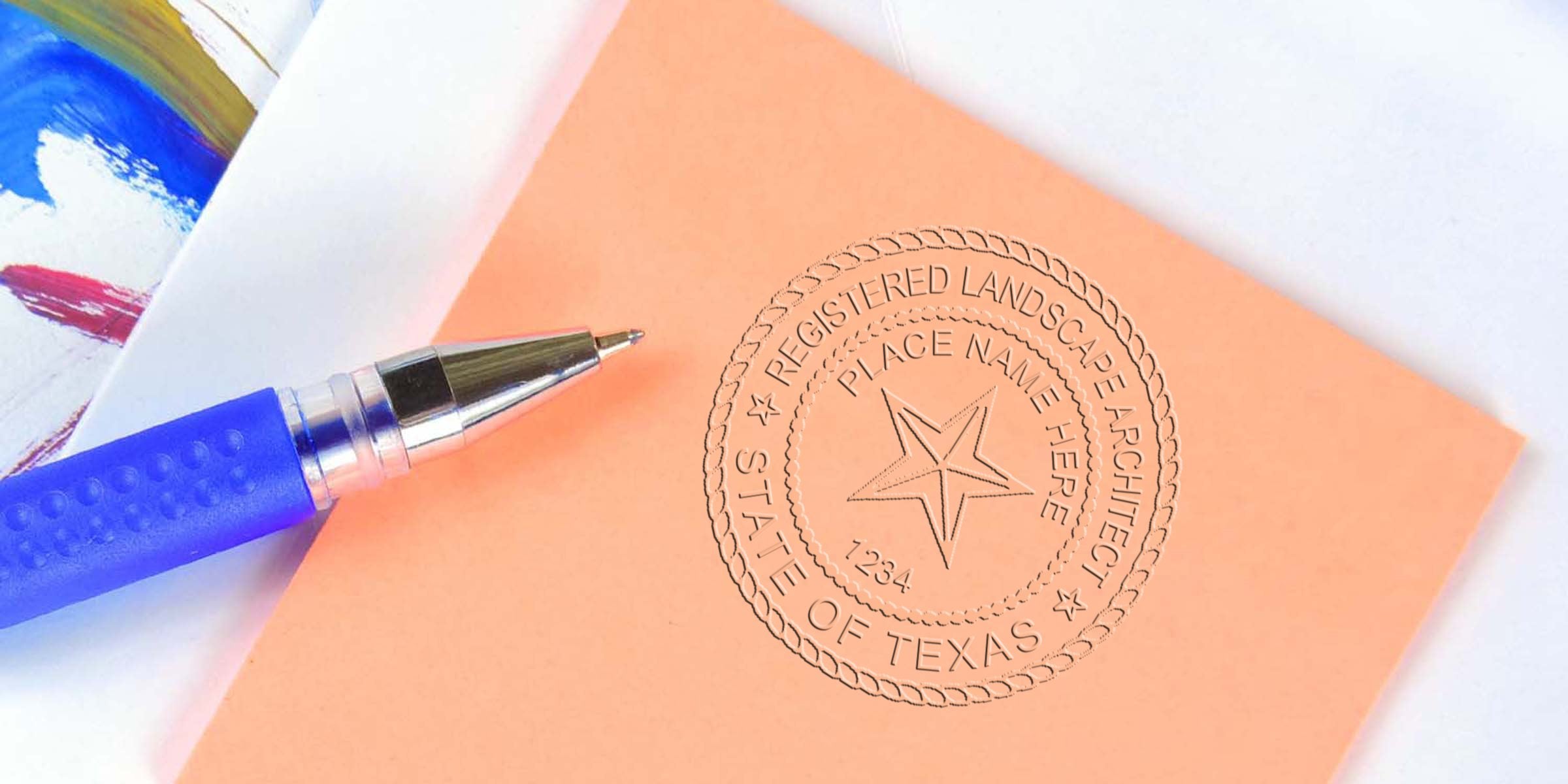 Blue pen next to a Texas landscape architect seal on peach paper, meeting Texas landscape architect certification guidelines.
