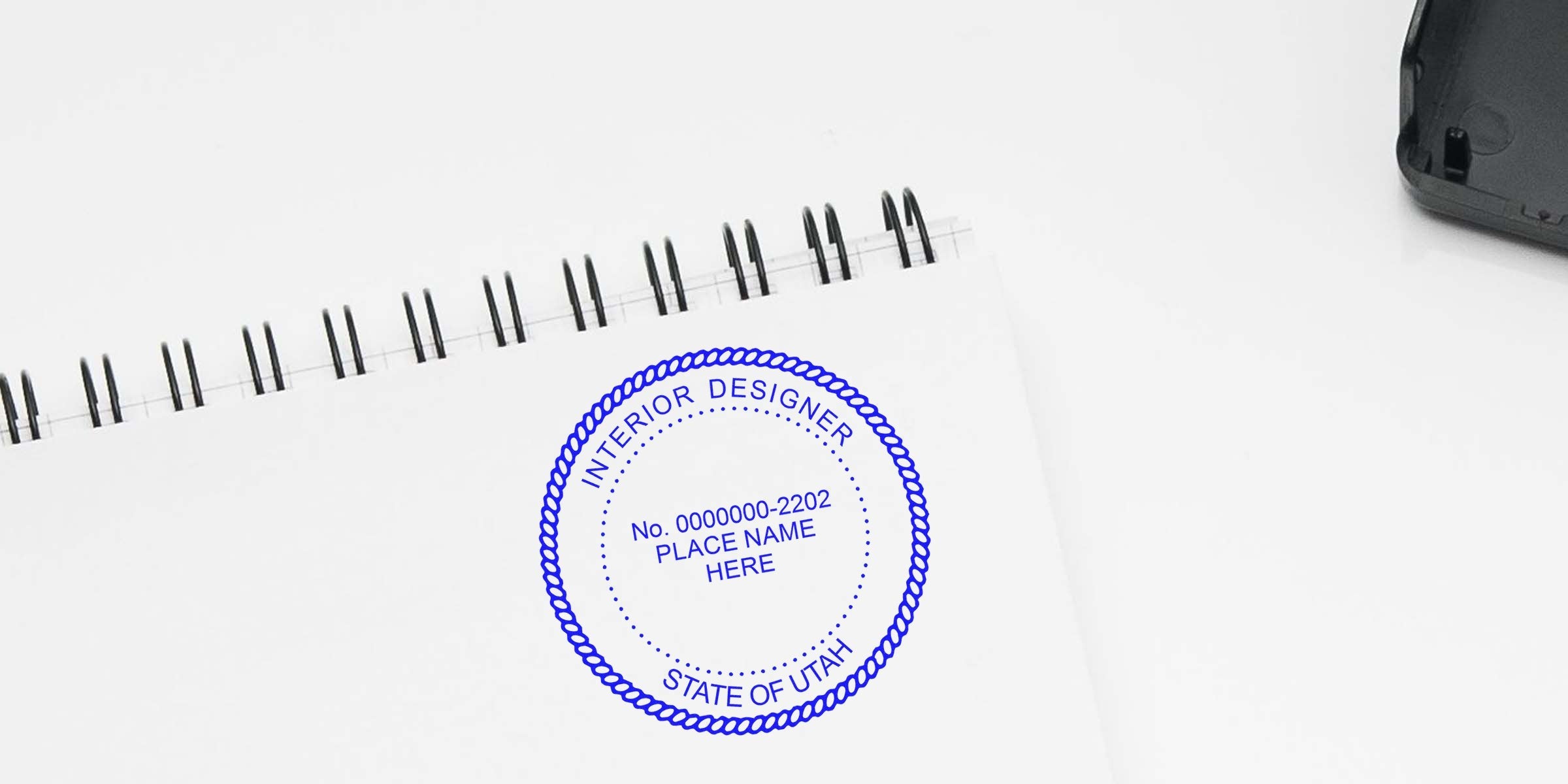 Custom Utah interior designer seal stamped on white spiral notebook, meeting state certification design seal requirements.