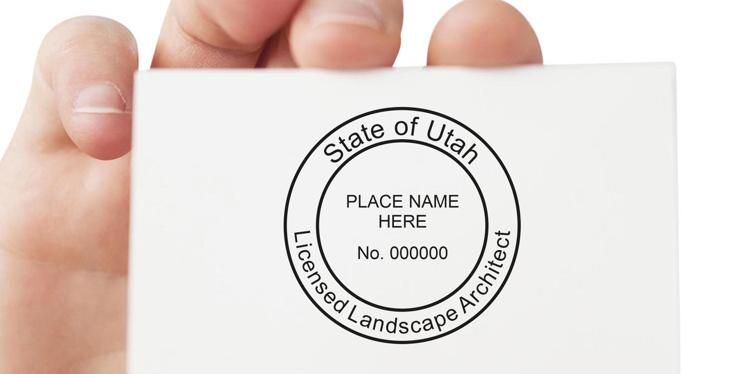 Hand holding a white card with a Utah landscape architect stamp, showcasing the cost of the Utah landscape architect stamp.