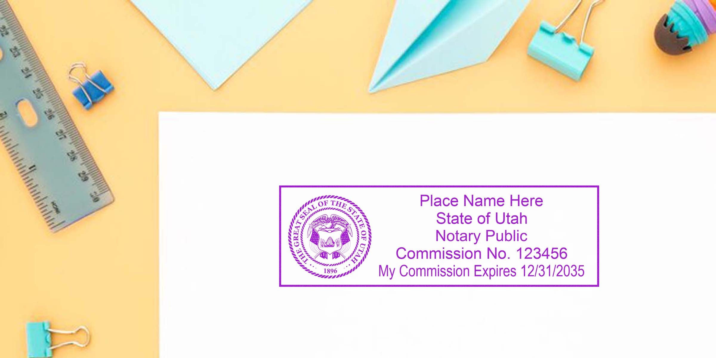 Utah notary public stamp with commission number and expiration date on white paper, surrounded by office supplies, part of Utah Notary Kit and Starter Kit.