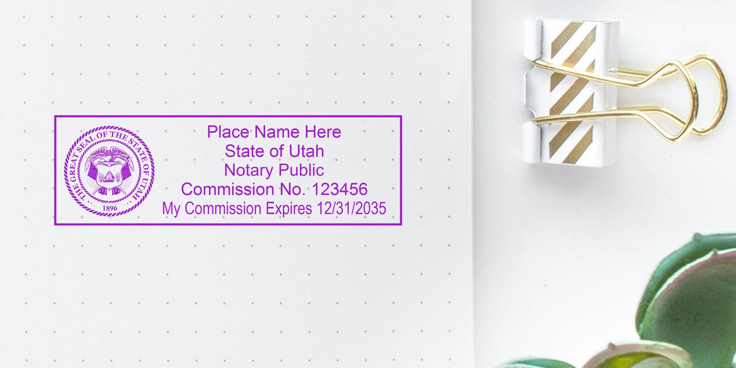 Utah notary public stamp with commission number and expiration date on dotted paper, alongside a gold binder clip and succulent, highlighting key items from a Utah notary kit and handy notary supplies.