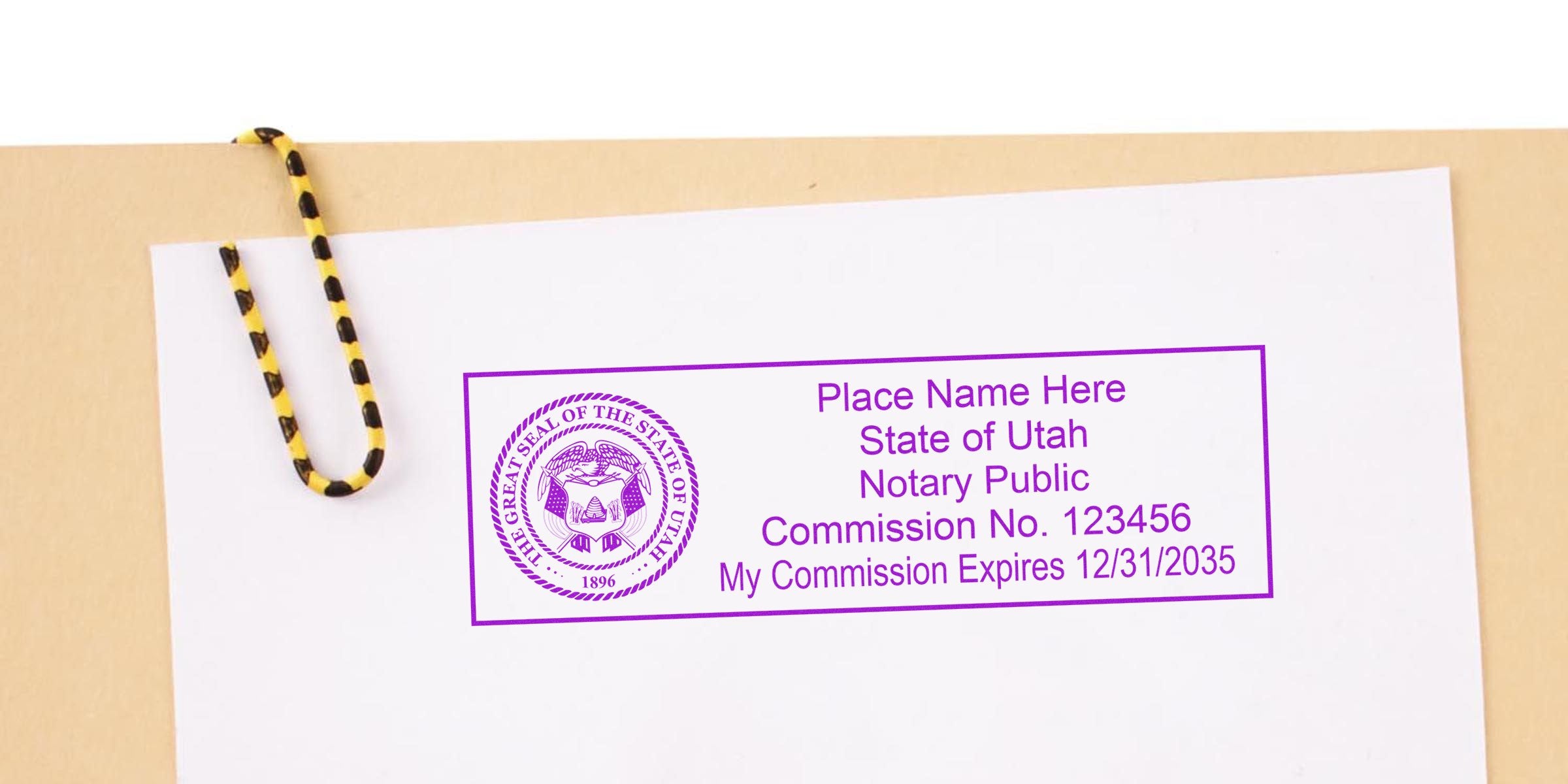 Utah notary stamp with commission number and expiration date on white paper, clipped with yellow and black paperclip, part of Utah notary supplies.