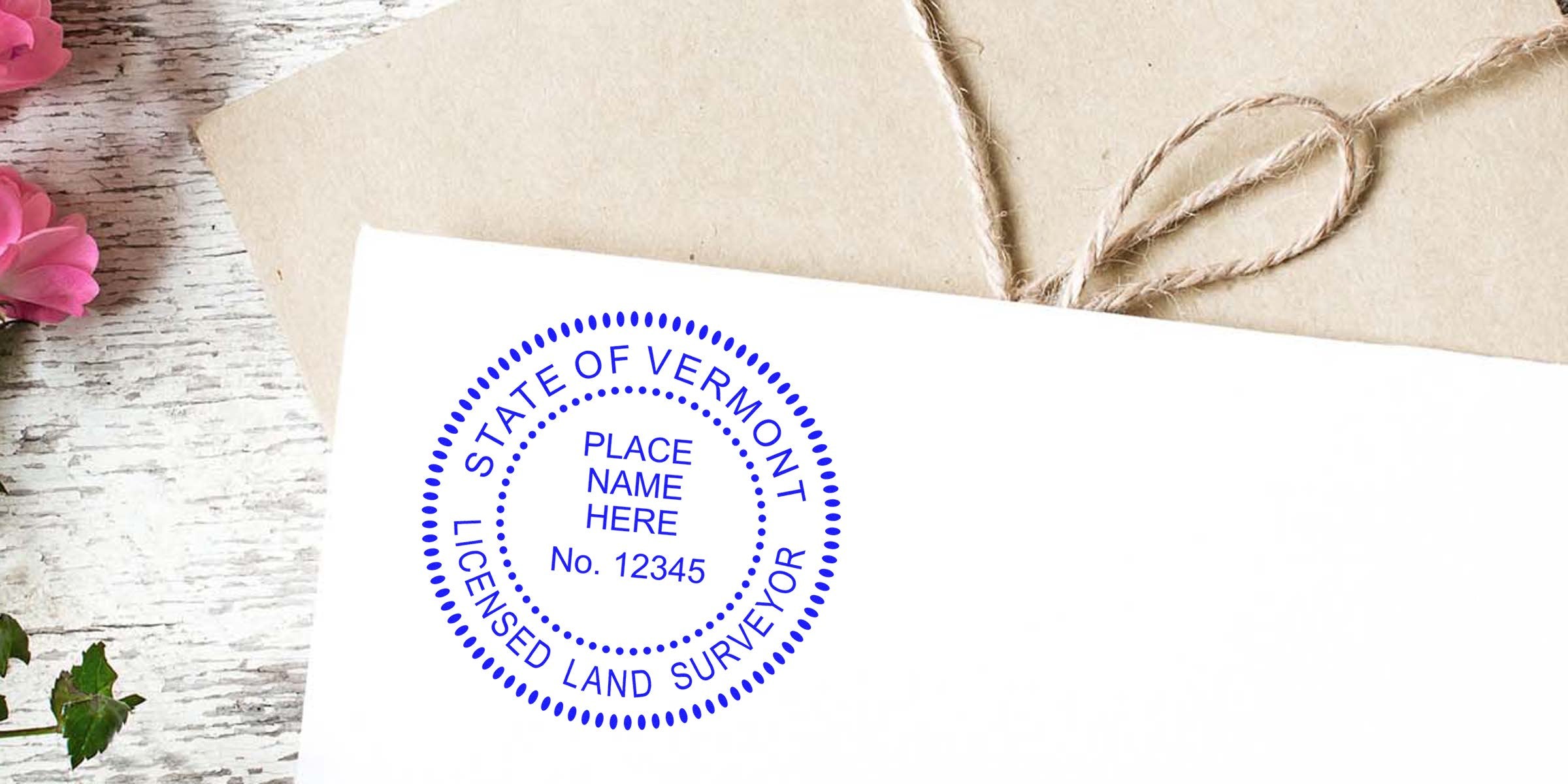 Vermont land surveyor seal embossed on white envelope, tied with rustic twine and pink flowers, showcasing a professional land surveyor embosser for Vermont land surveying services.