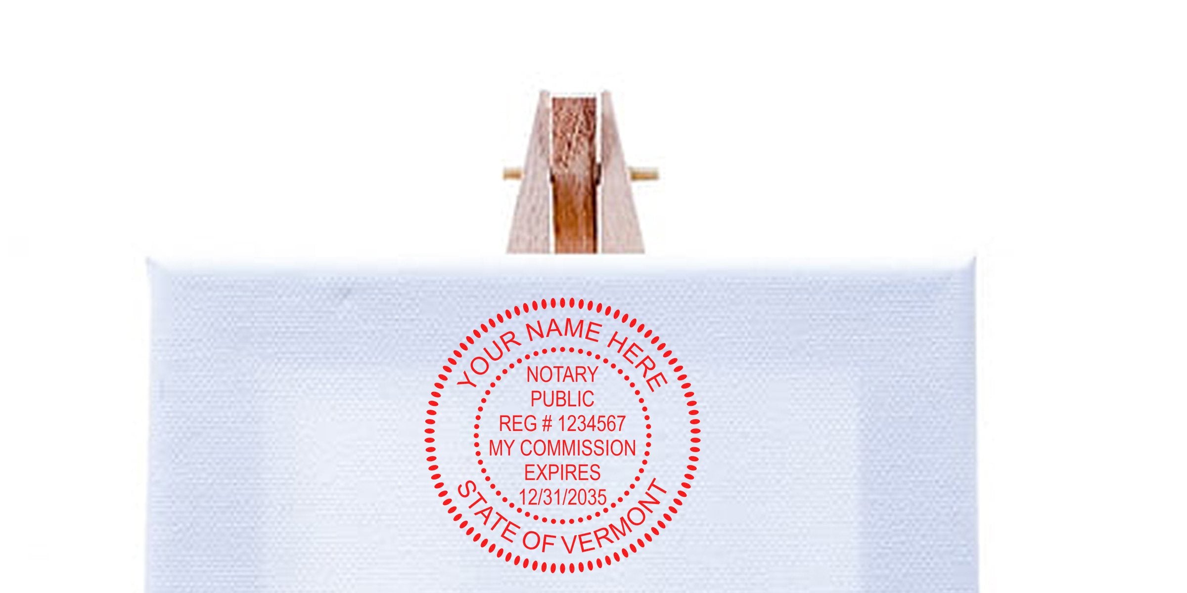 Custom Vermont notary seal stamp on white fabric, held by wooden clothespin, featuring personalized details and commission expiration date.