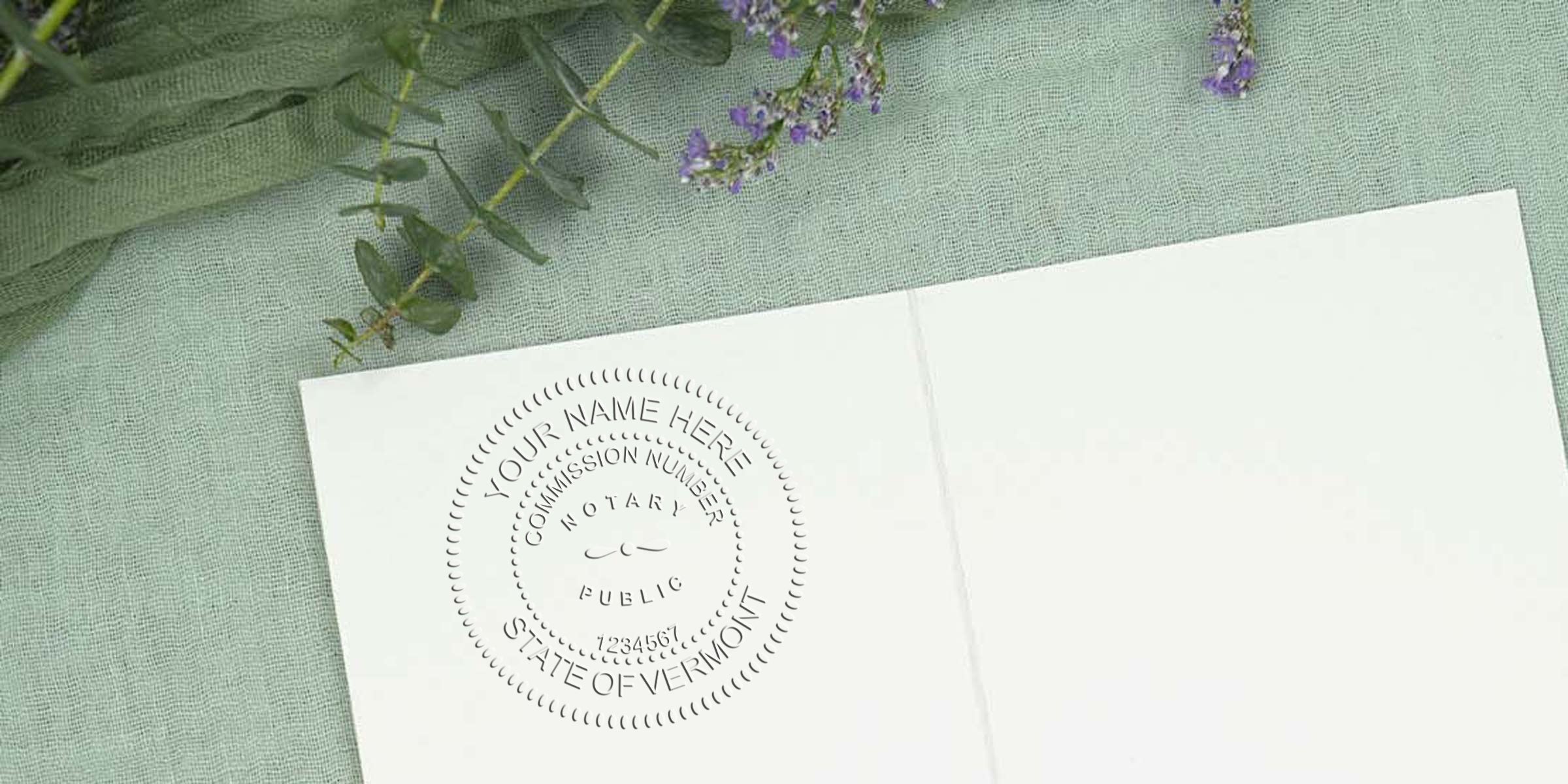 Custom Vermont notary stamp on white paper with green fabric and purple flowers background, compliant with Vermont notary requirements.