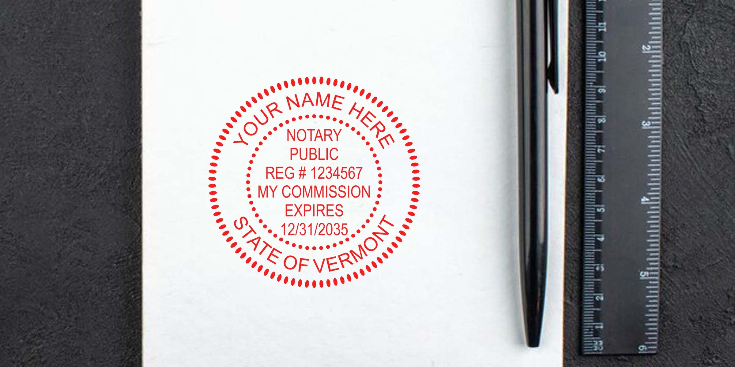 Vermont notary stamps on white paper with commission expiration date, alongside a black pen and ruler.