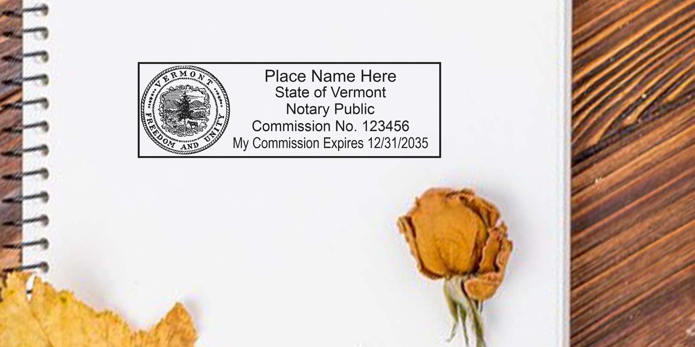 Vermont notary public stamp on notebook with dried flower on wooden table, showing how to become a Vermont notary using a Vermont notary guide.