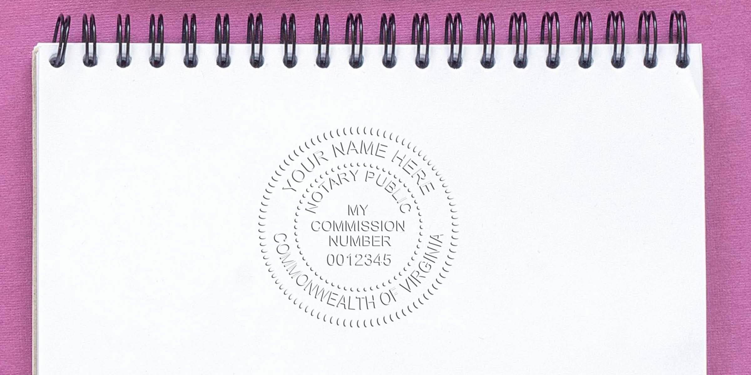 Virginia notary stamp on white spiral notebook with pink background, showing commission number 0012345, demonstrating how to become a Virginia notary.