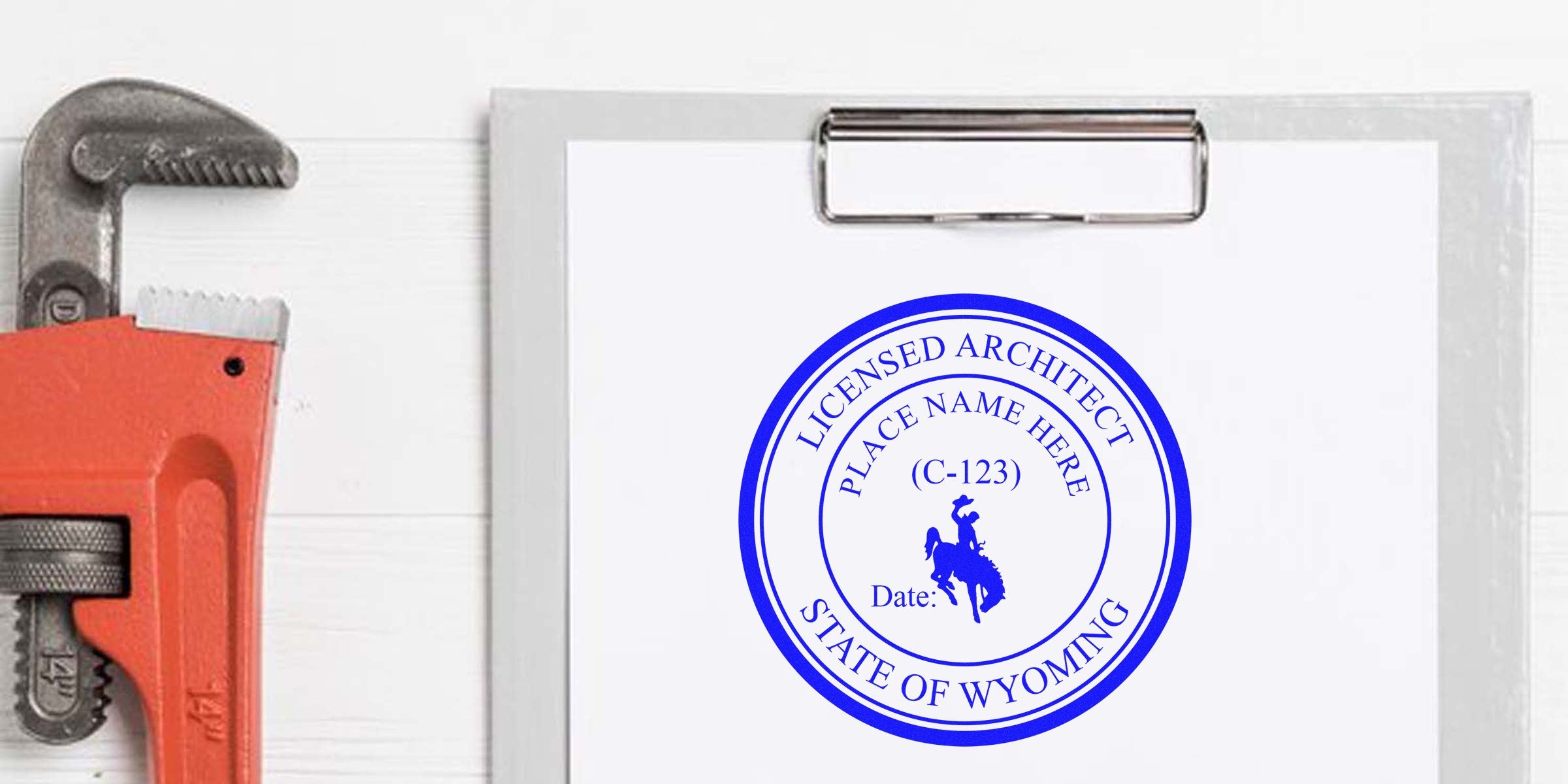 Clipboard with Wyoming architect stamp and pipe wrench, highlighting Wyoming architect stamp and related regulations.