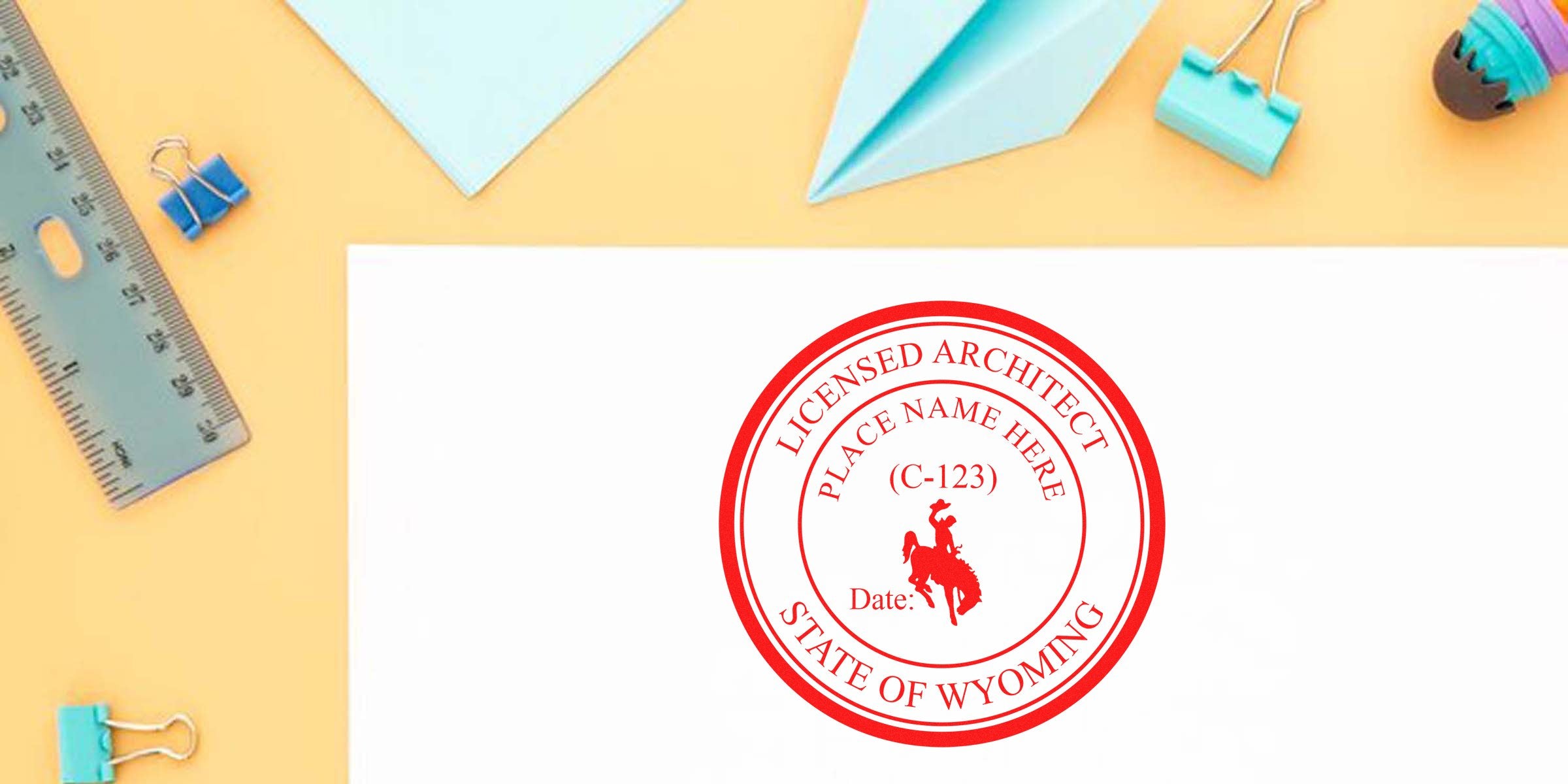 Wyoming architect stamp on white paper with office supplies and ruler on yellow background, showcasing Wyoming architect stamp and tips for ordering architect stamps.