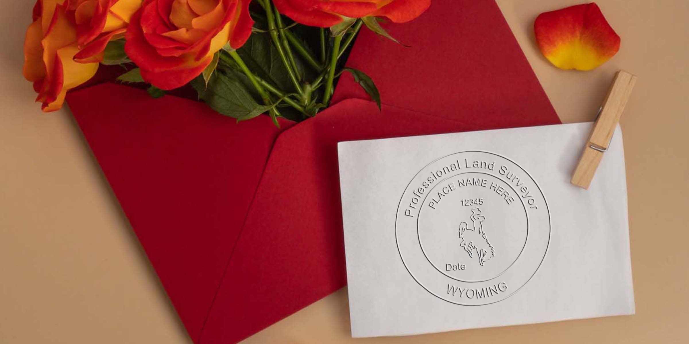 Red envelope with orange roses and Wyoming land surveyor stamp embossed on white paper, meeting all land surveyor stamp requirements.