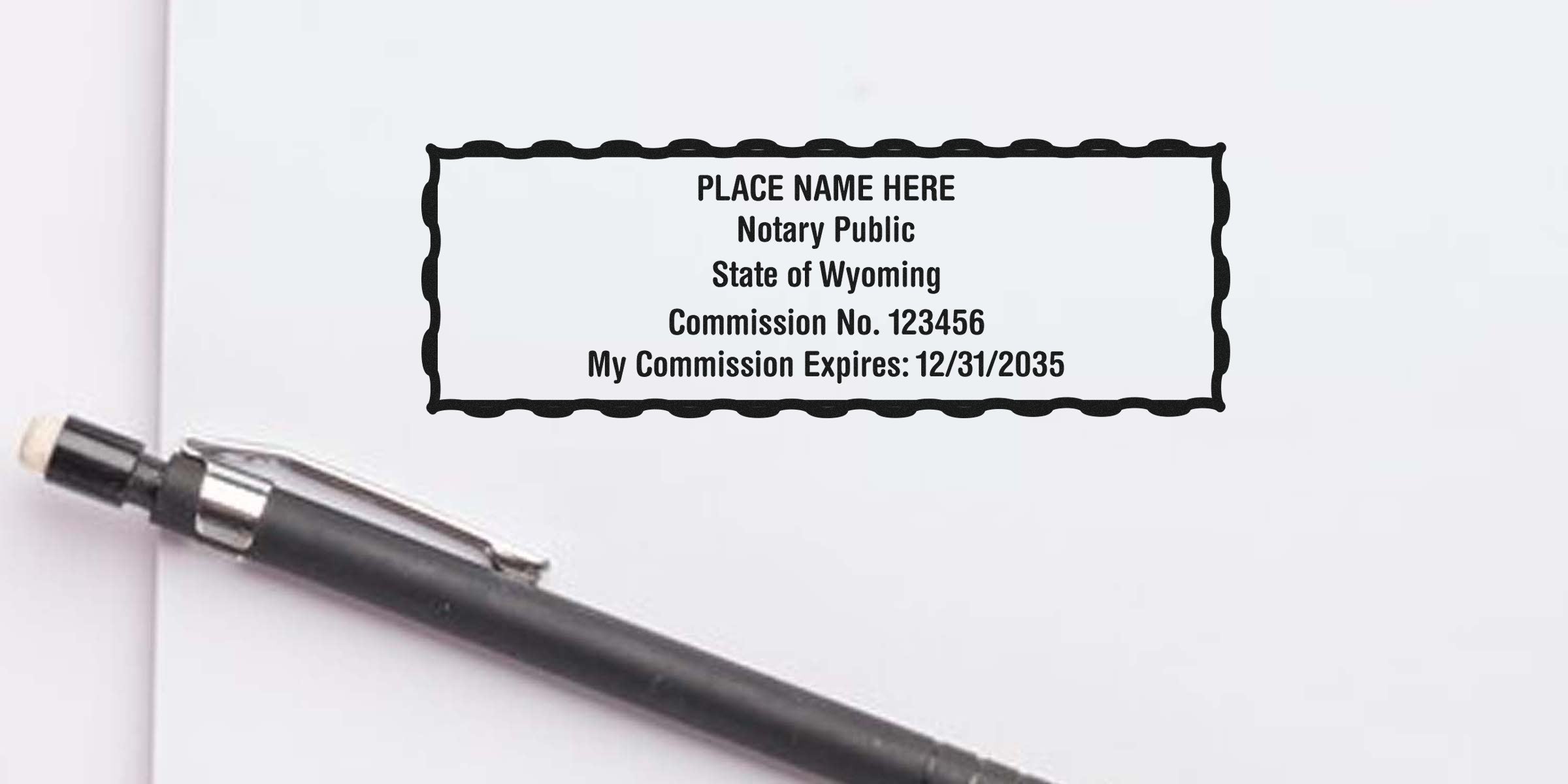Custom Wyoming notary seal stamp with commission number and expiration date on white paper next to a black pen, ideal for ordering a Wyoming notary seal.