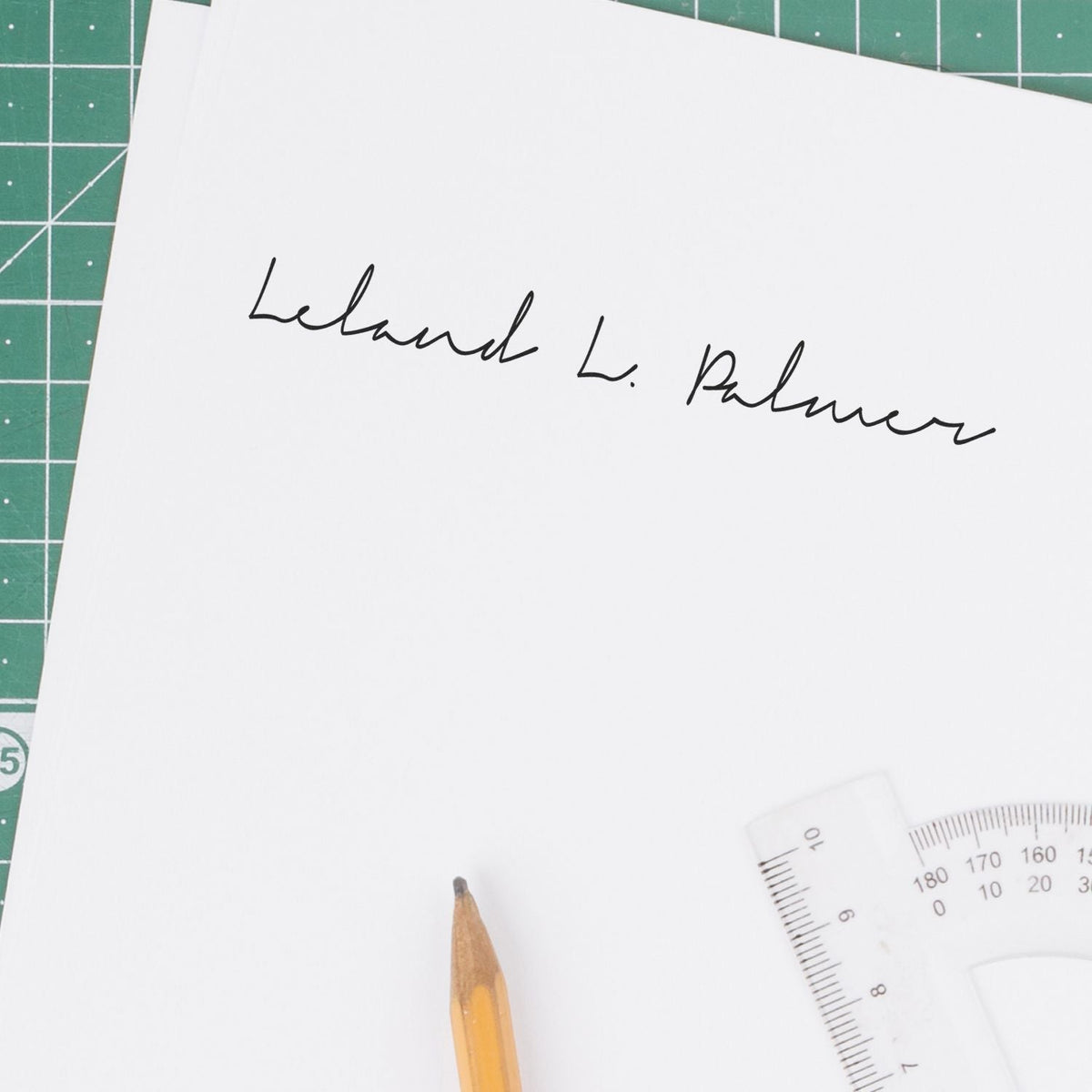 Custom wood handle signature stamp printing a signature on paper