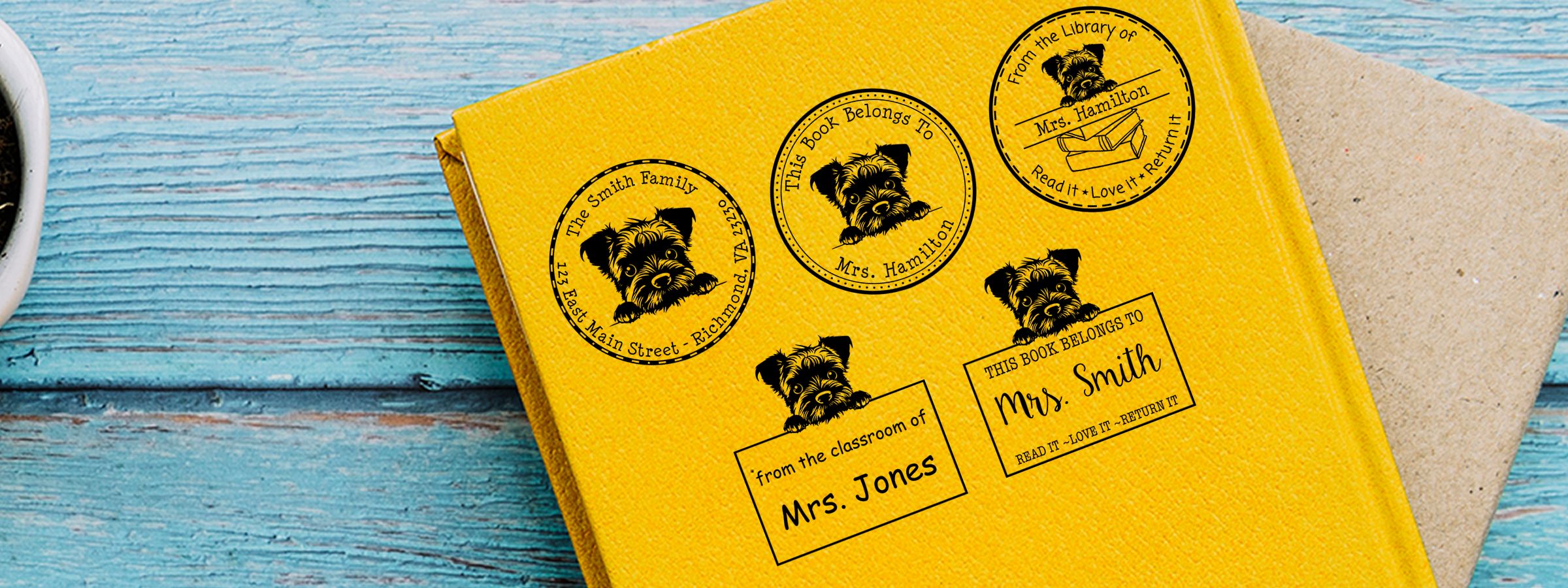 Yellow book cover with Border Terrier Dog Stamps and Custom Seals on blue wood, with a tan envelope behind it.