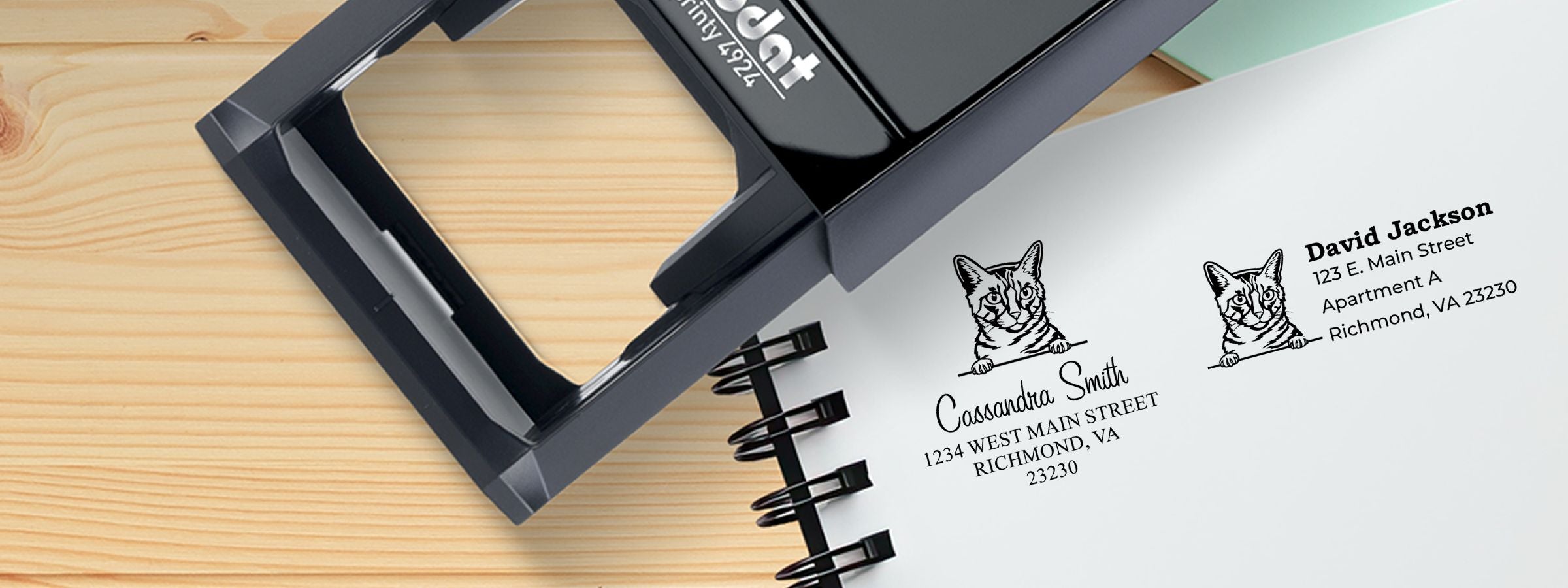 Black self-inking stamp on a wooden desk beside cat labels for Cassandra Smith and David Jackson, California Spangled Cat Stamps and Custom Seals.
