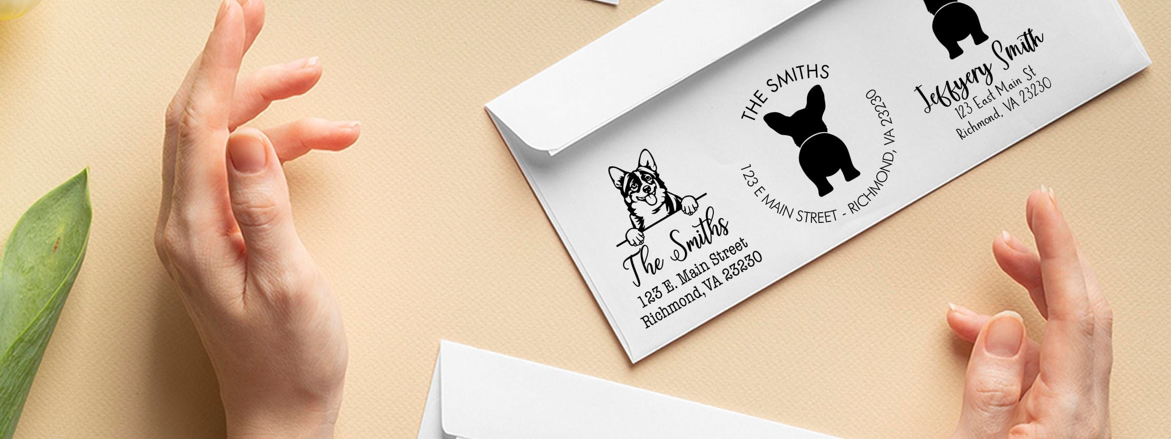 Hands holding a white envelope with pet address labels, dog and cat silhouettes, The Smiths, and Corgi Dog Stamps and Custom Seals.