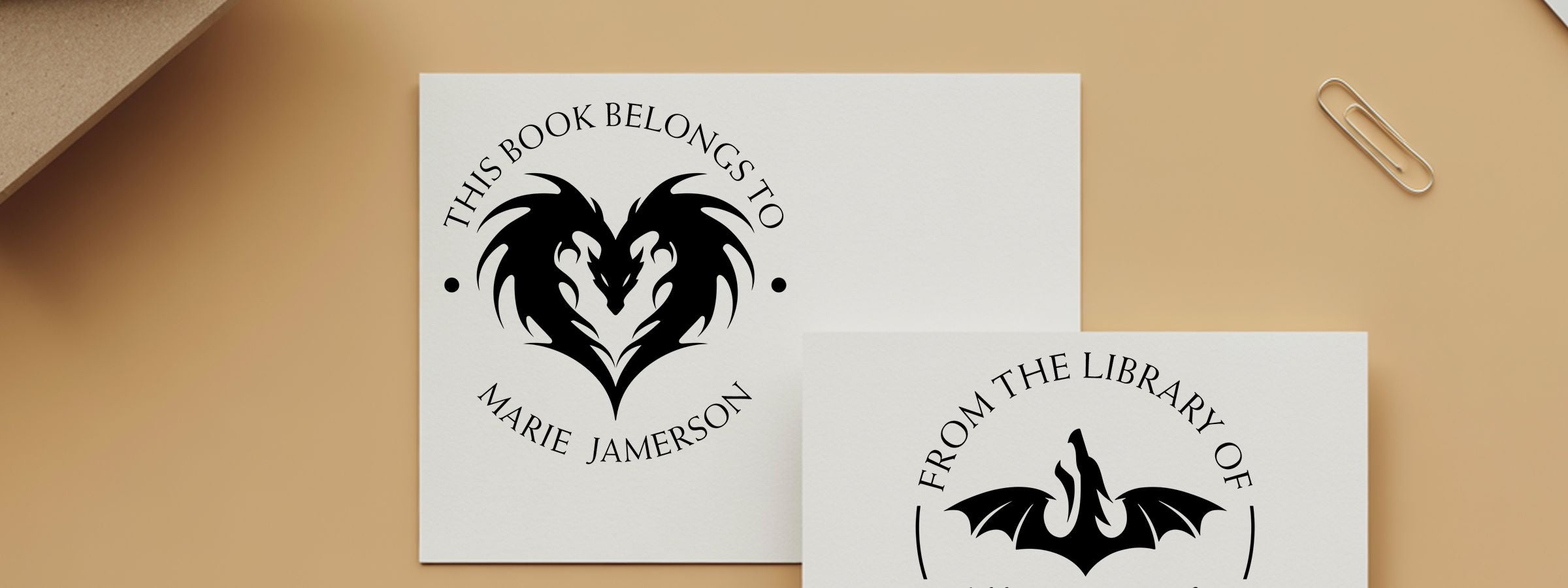 Fantasy Creatures Designer Stamps: two bookplates on tan—dragon-heart for Marie Jamerson and bat “From the Library of” with a paper clip.