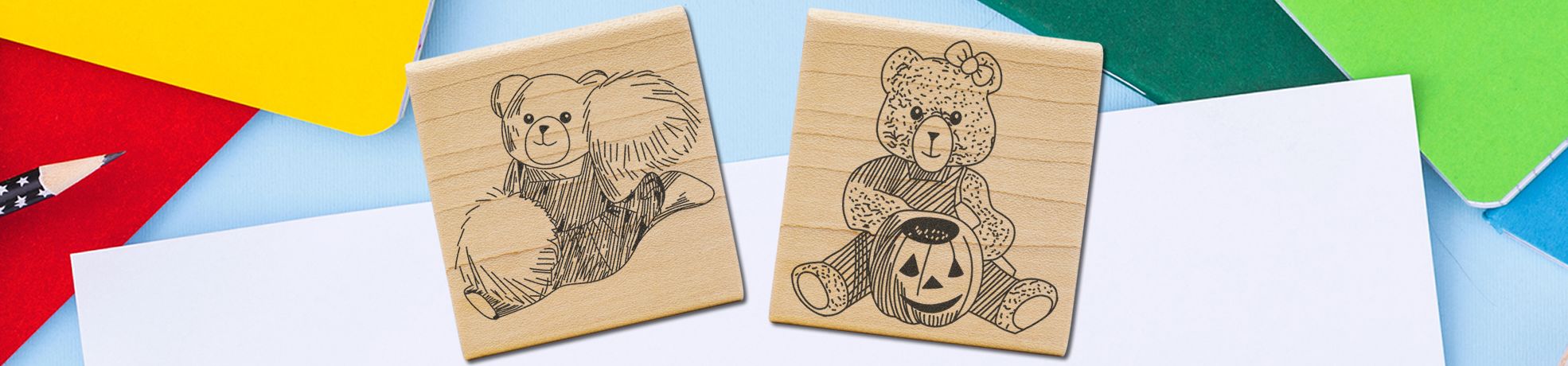 Art Rubber Stamps & Craft Stamps featuring two wooden teddy bear stamps, one with a plush toy and one with a pumpkin on colorful paper.